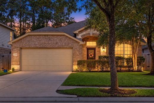 Charming brick home with a two-car garage and inviting front entrance, surrounded by mature trees and well-maintained landscaping, set against a serene evening backdrop. Charming brick home with a two-car garage and inviting front entrance, surrounded by mature trees and well-maintained landscaping, set against a serene evening backdrop.
