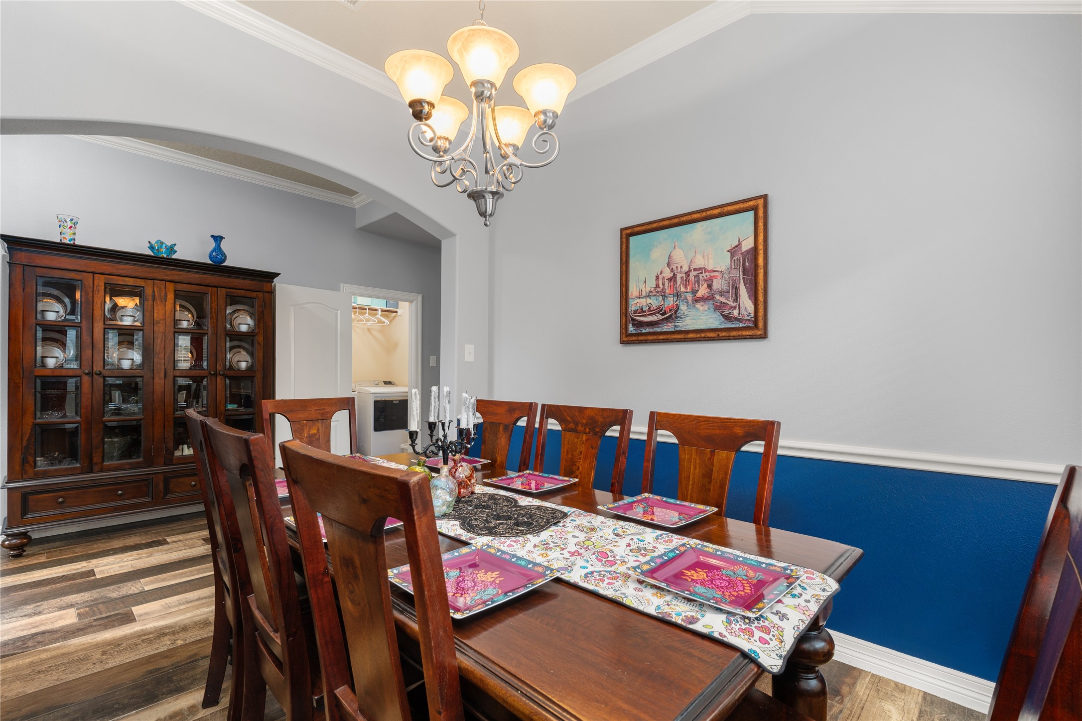 Elegant dining room featuring rich wood furniture, a stylish chandelier, and a vibrant accent wall, perfect for hosting gatherings. Elegant dining room featuring rich wood furniture, a stylish chandelier, and a vibrant accent wall, perfect for hosting gatherings.