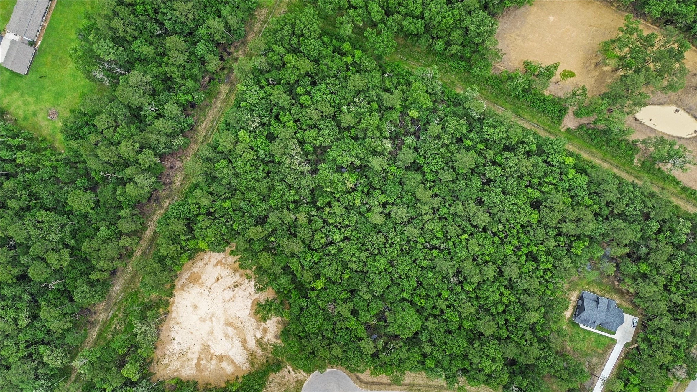 From above, mature trees blanket the property, offering buyers the opportunity to selectively clear a homesite while preserving a natural wooded setting.