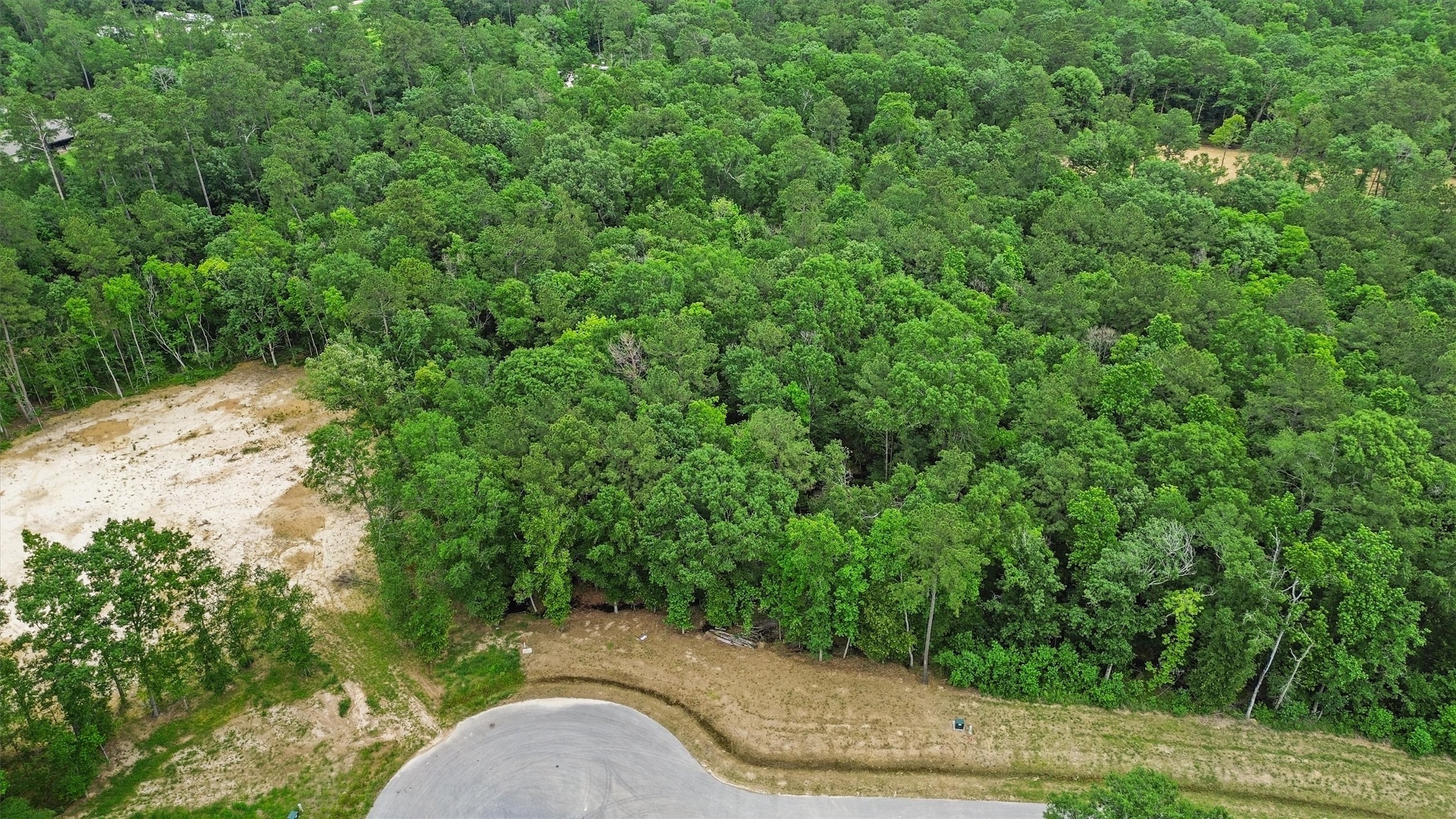 Tucked at the end of a cul-de-sac, this wooded acreage homesite offers the privacy and space buyers seek when building outside a traditional suburban setting.