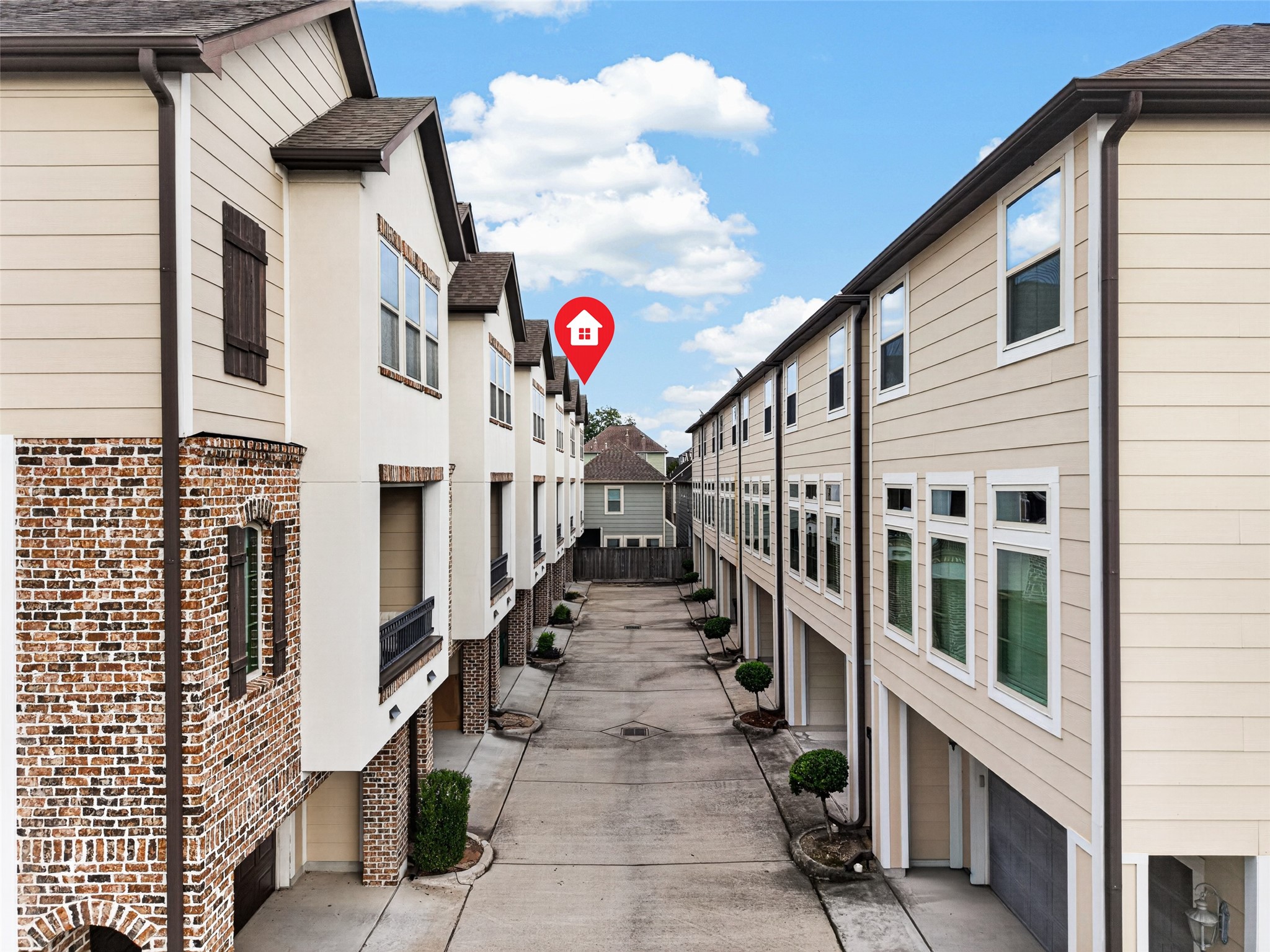 Exterior view of the townhome community, highlighting the shared driveway, neighboring residences, and the property's location within the development.