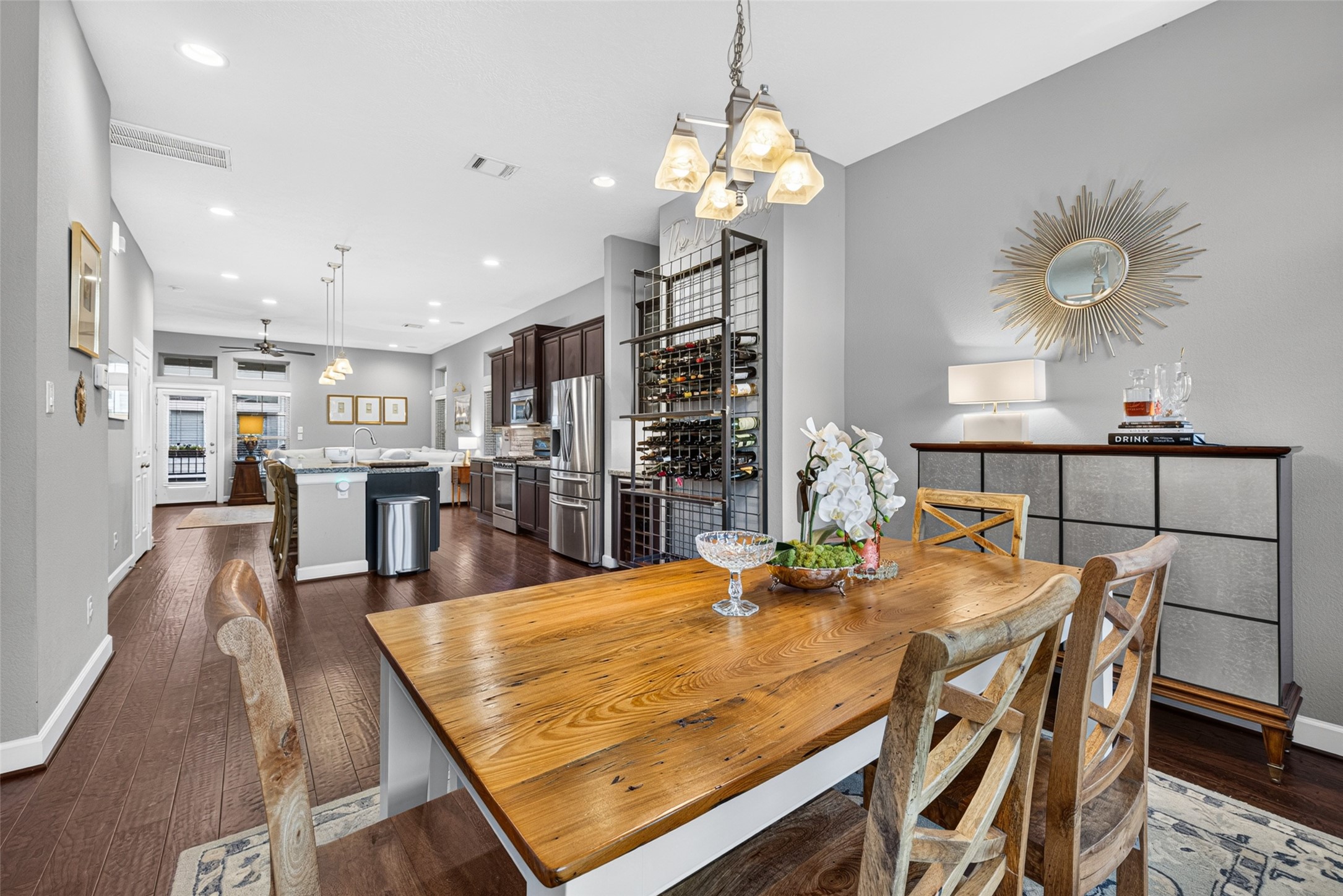Dining area with hardwood floors and elegant lighting, seamlessly connecting to the open-concept kitchen and living space.