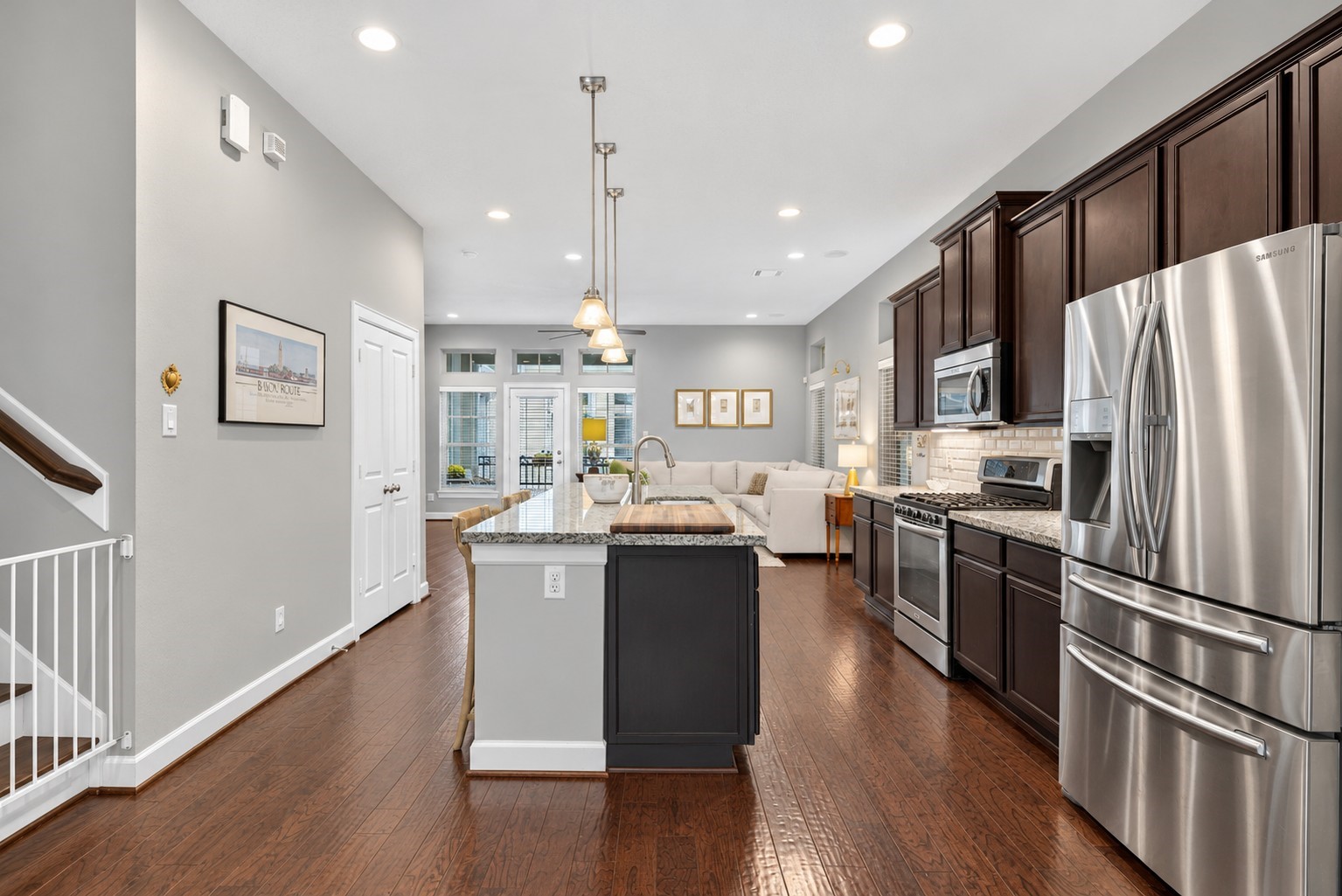 Another perspective highlights the kitchen's ample cabinetry, counter space, and stainless steel refrigerator.