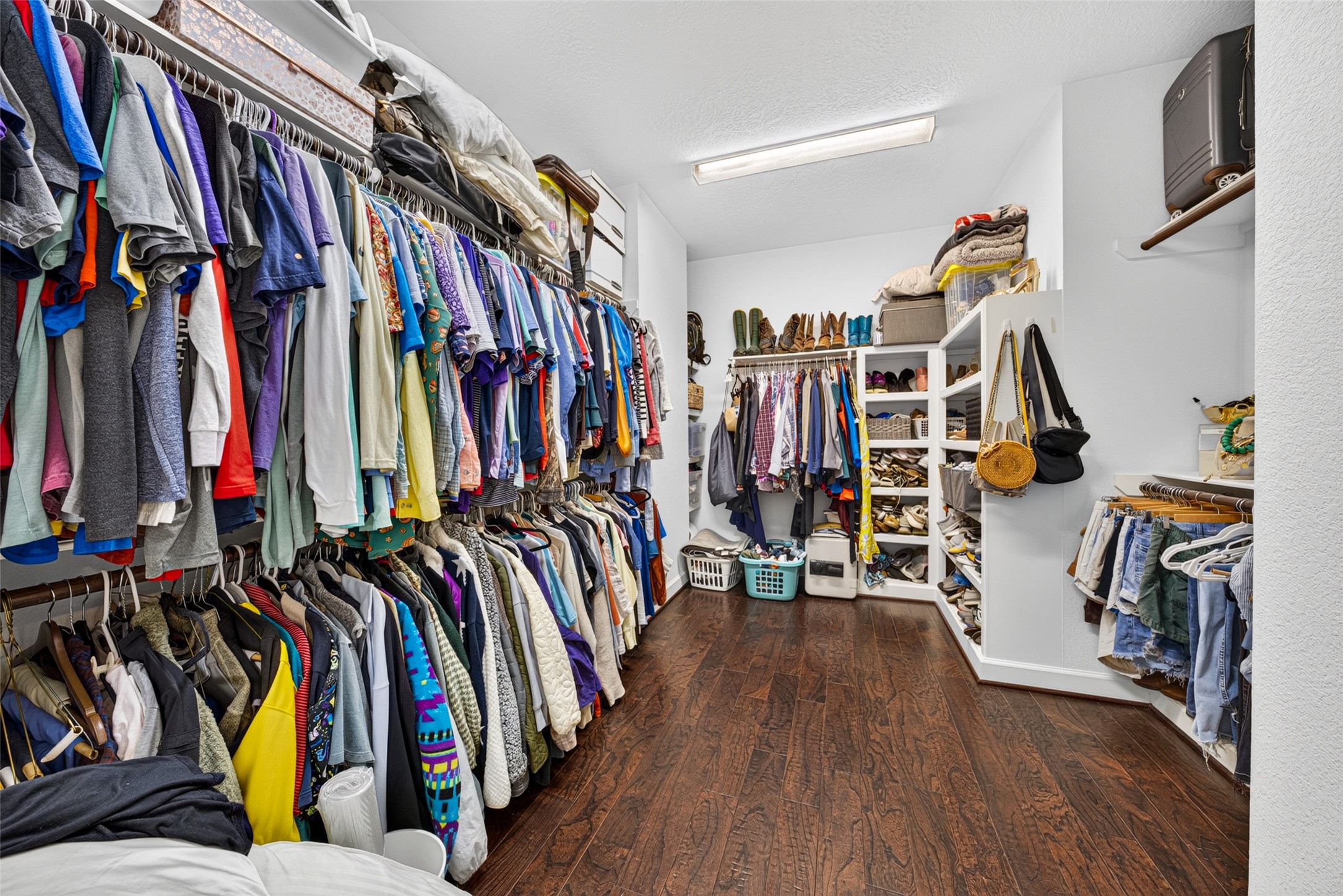 Primary Walk-in closet with ample built-in shelving and hanging space for organized storage.