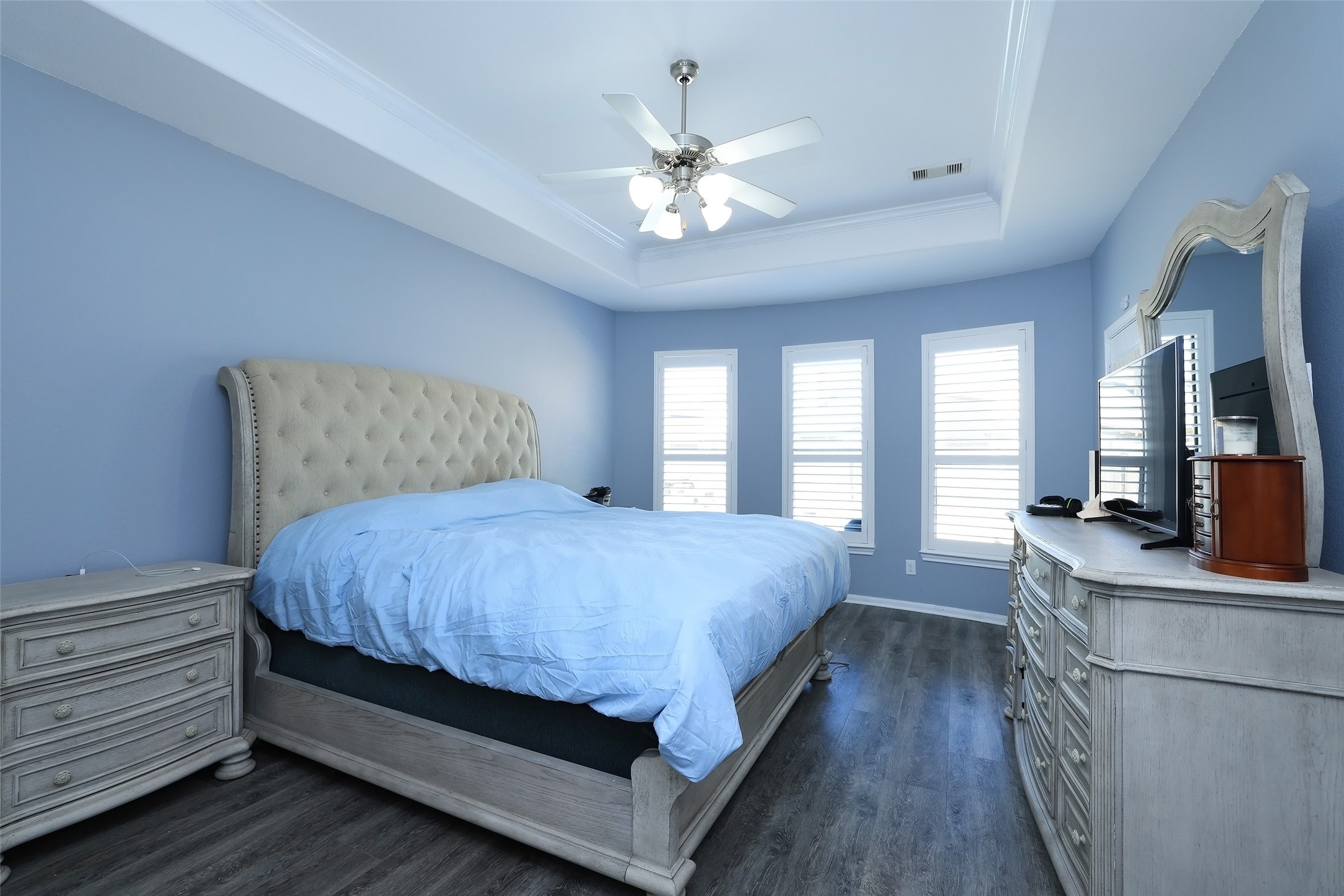 Oversized master bedroom with upgraded flooring, and a door leading to the patio area