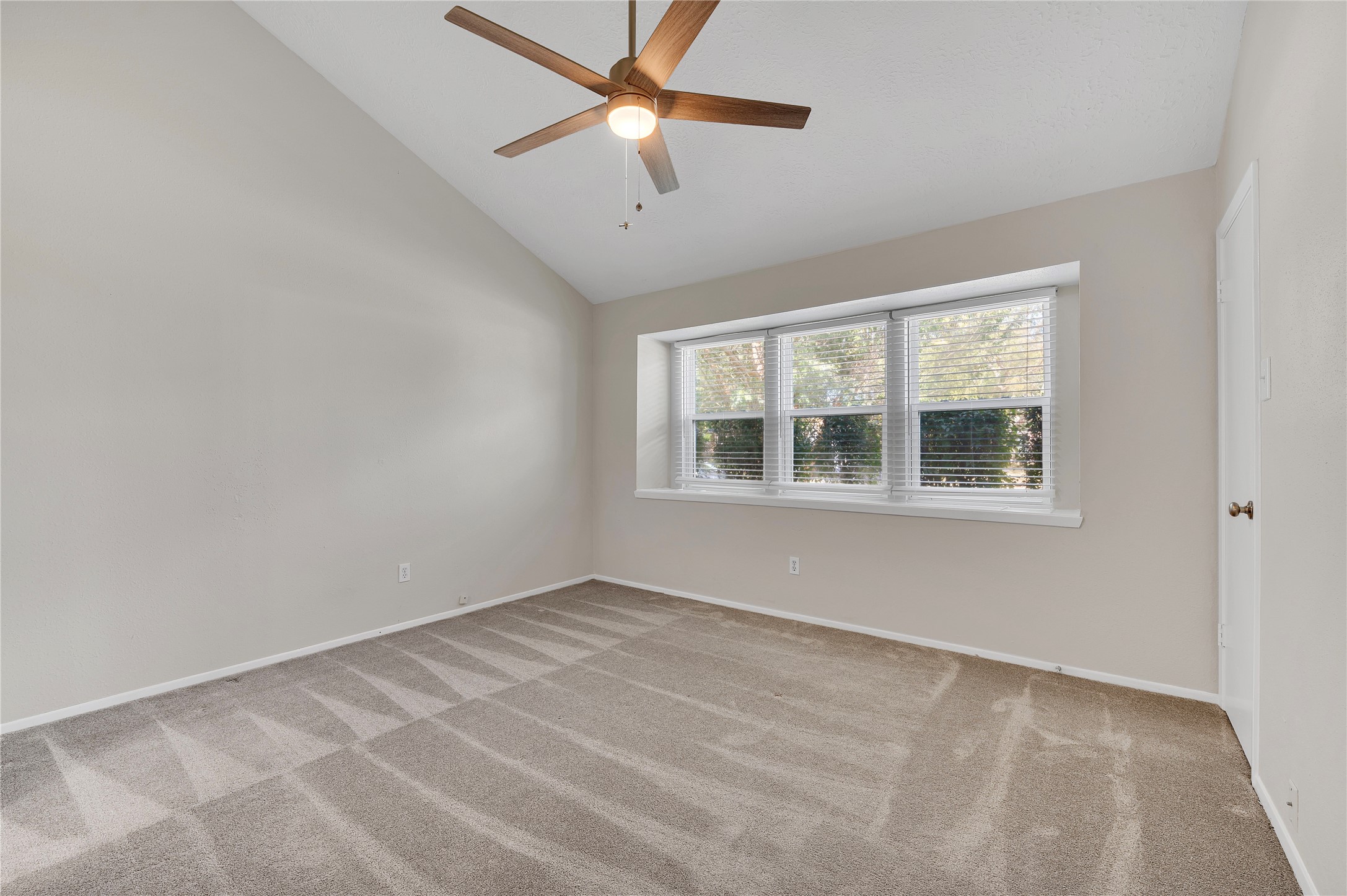 Large primary bedroom with high ceilings.