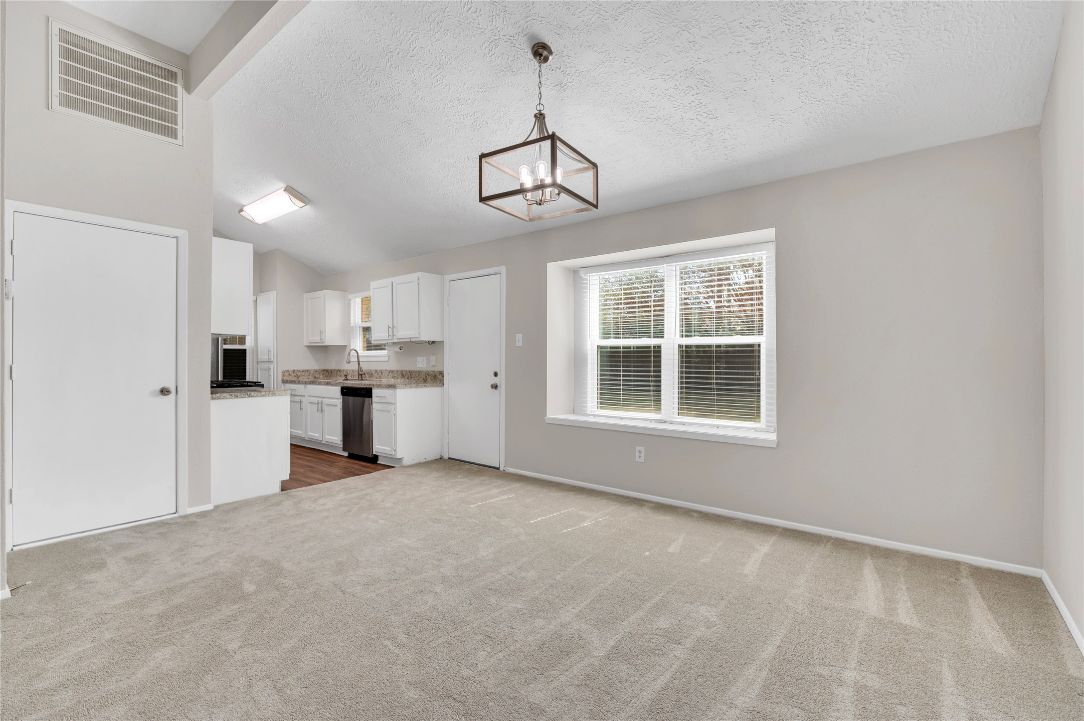 Dining area with backyard views, open to kitchen and living room.