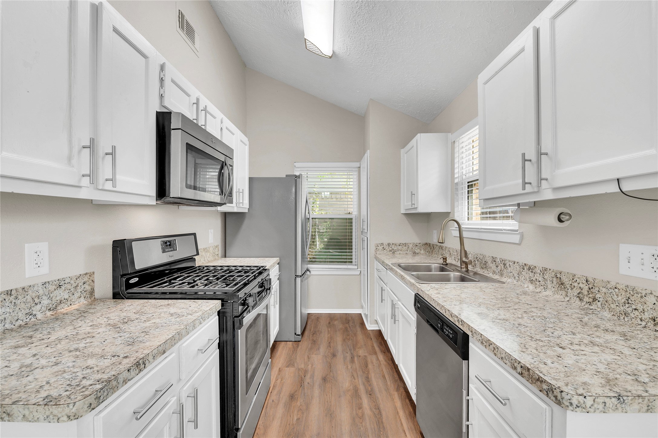 Spacious kitchen ample counter top space and wood cabinet storage. Stainless gas range/oven, dishwasher, microwave and refrigerator.