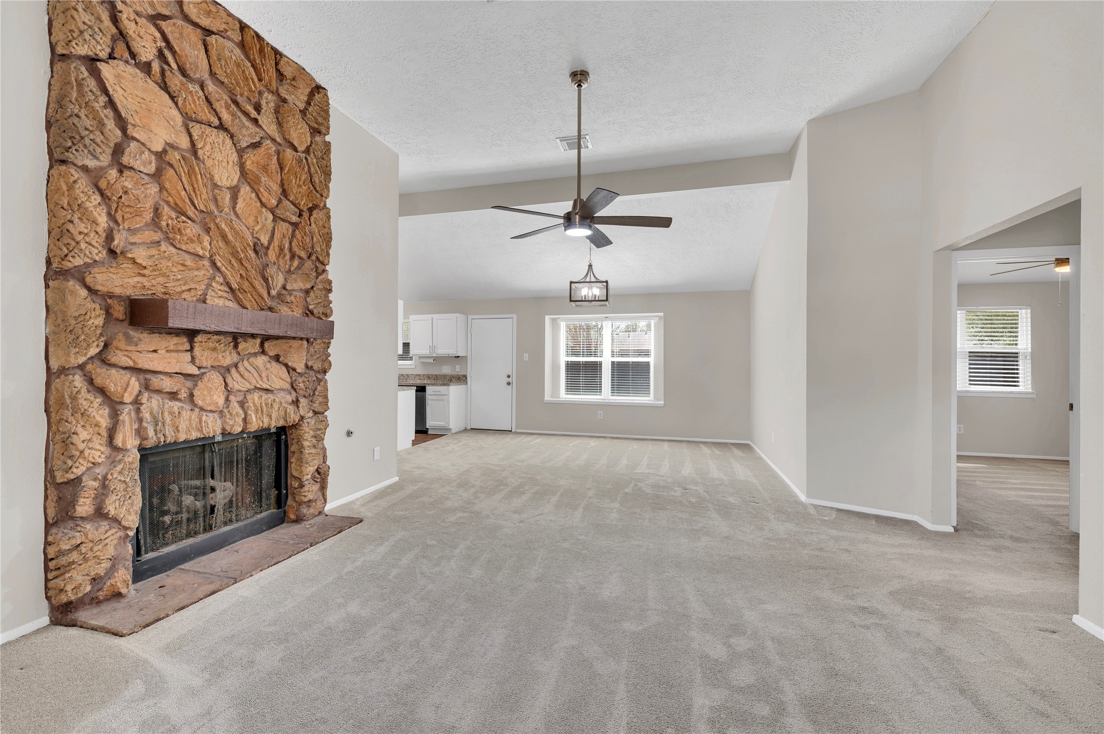 Large living room with stone fireplace.