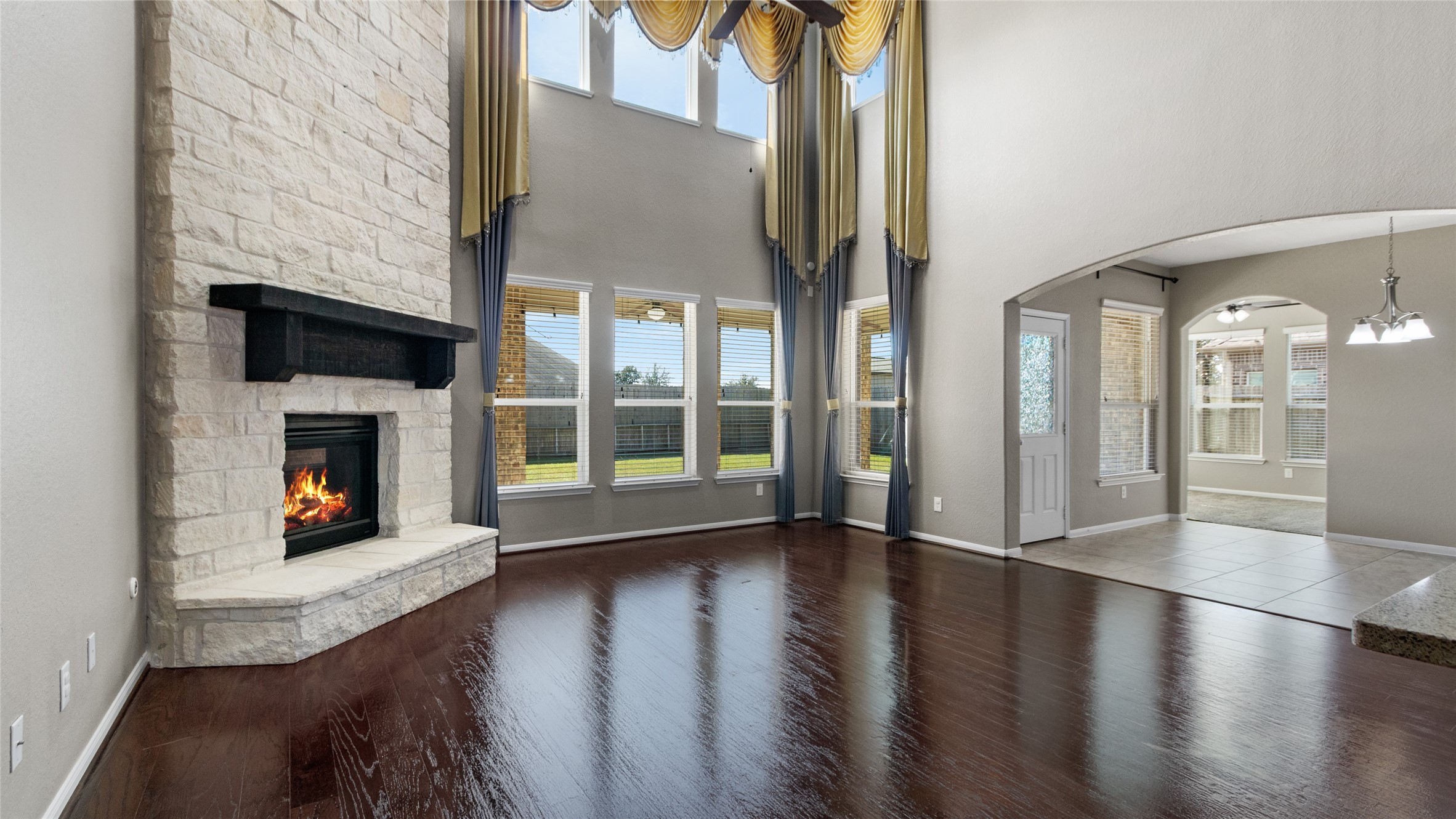 The large living space is brightened by oversized windows, a stunning stone fireplace from floor to ceiling that is open to the kitchen, breakfast room and sunroom.