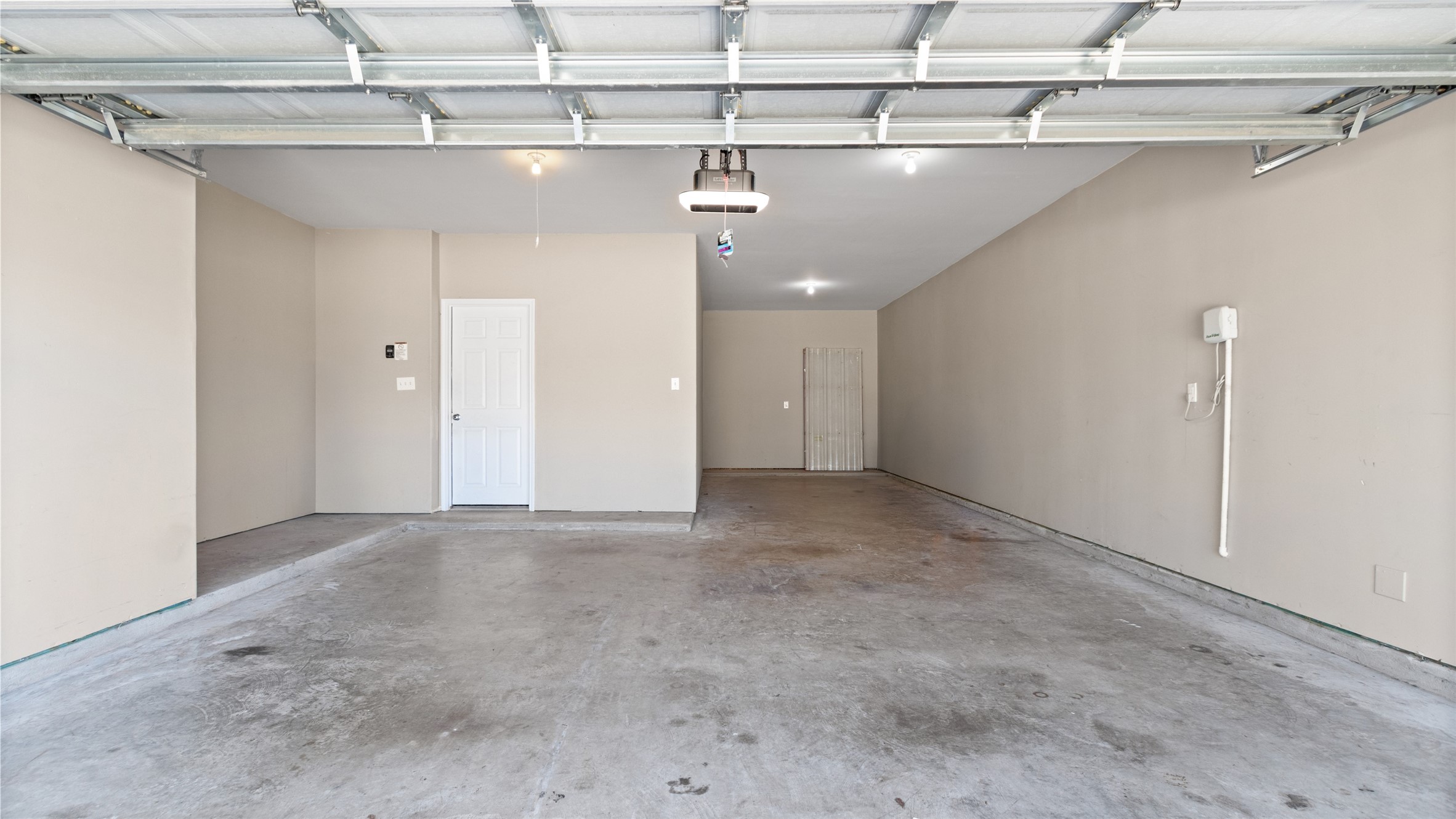 This three-car tandem garage offers ample space for vehicles, recreational equipment, and extra storage. The home features a recently installed sprinkler system with the control unit conveniently located on the garage wall.