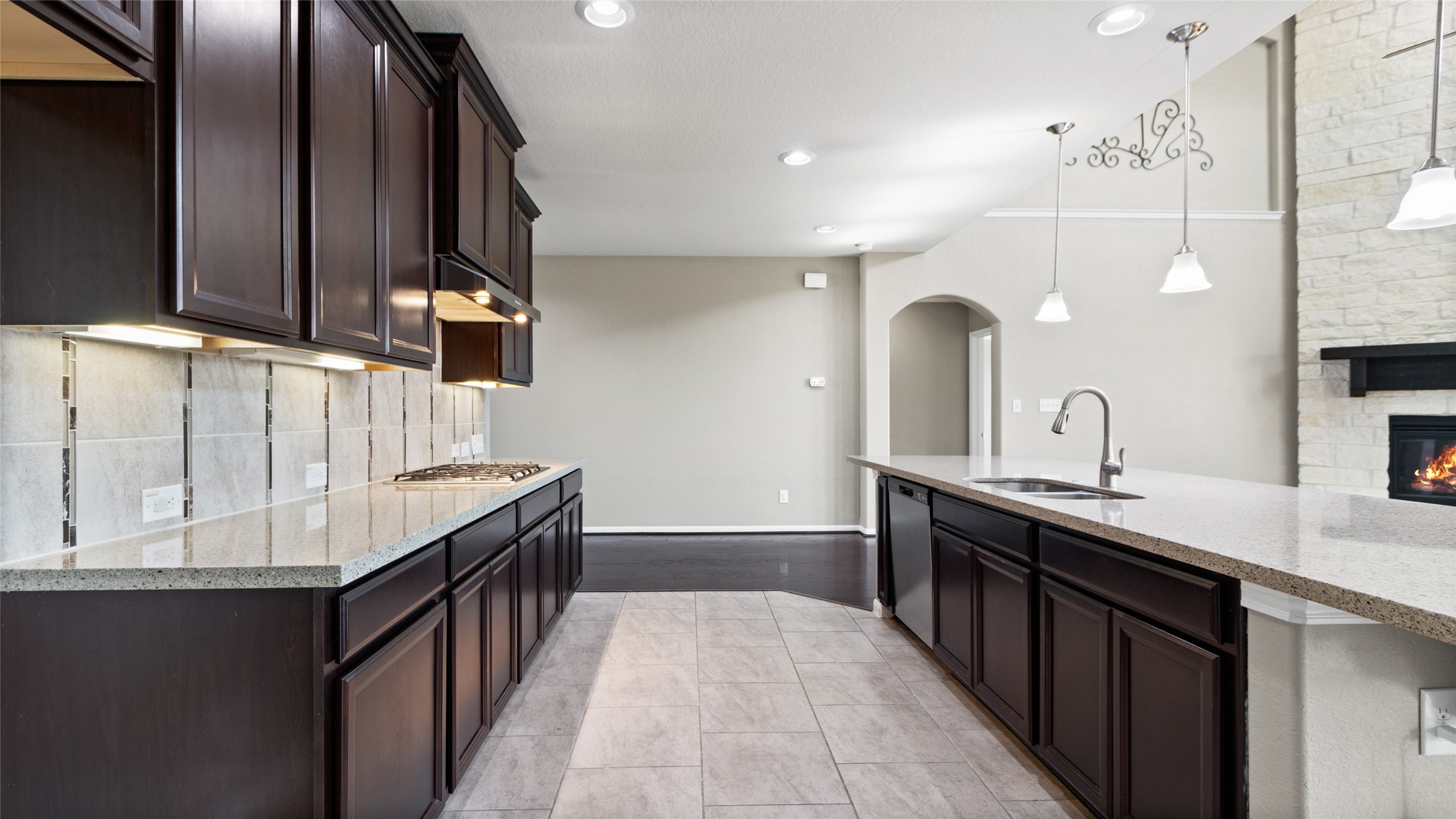 This spacious and inviting kitchen features abundant storage, under-cabinet lighting, a gas cooktop, and a massive island equipped with two deep stainless steel sinks. Open to both the living and breakfast areas, this kitchen is the perfect space for daily gathering and entertaining.