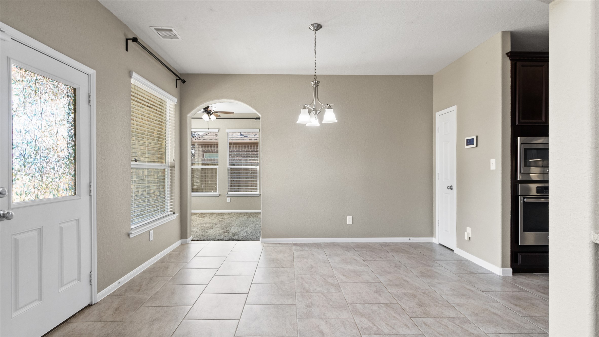 This spacious breakfast room is conveniently located adjacent to the kitchen and features a dedicated storage room. To the left, you will find access to a bright, inviting sunroom.