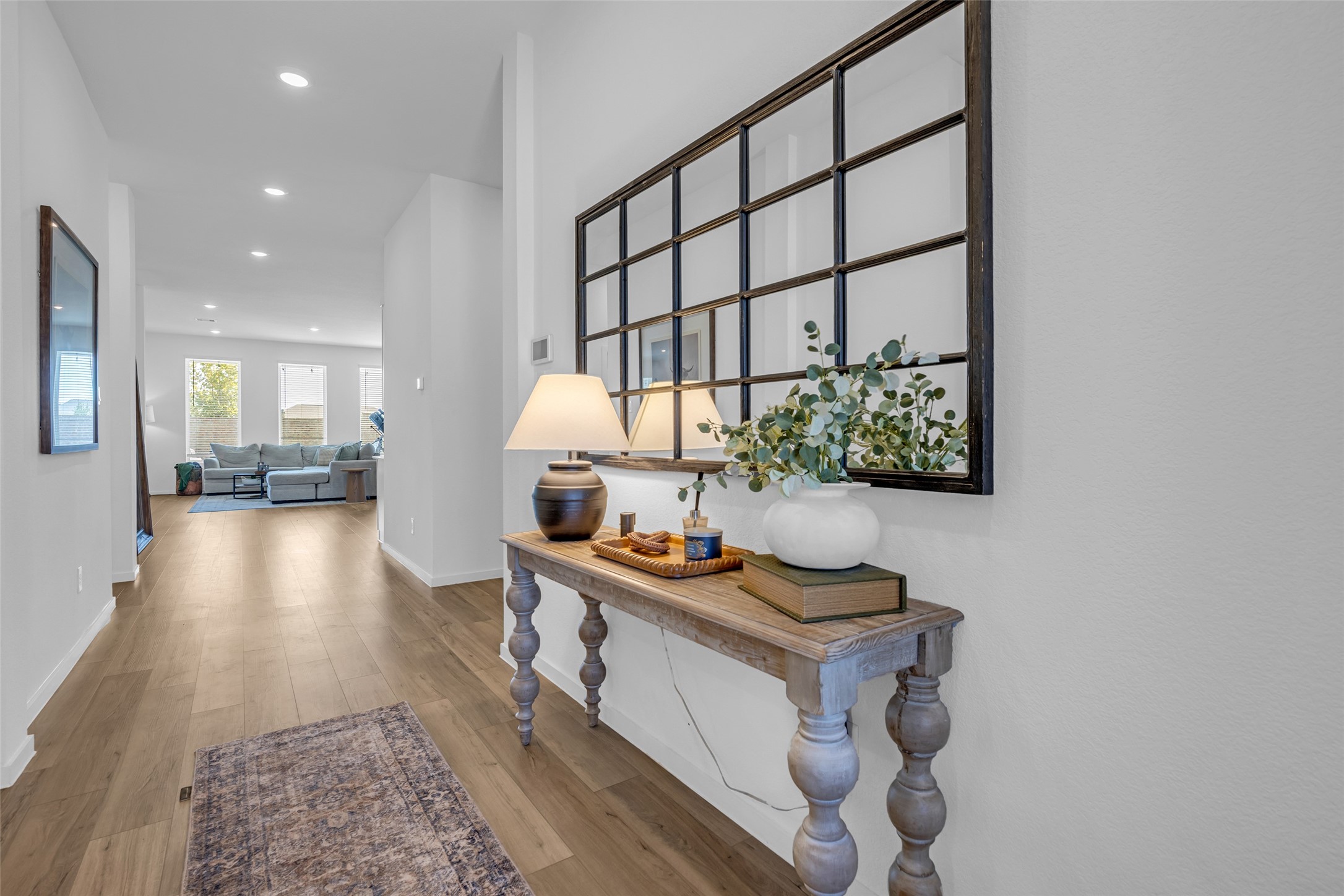Inviting hallway with elegant wood like floors leading to a bright and spacious living area Inviting hallway with elegant wood like floors leading to a bright and spacious living area