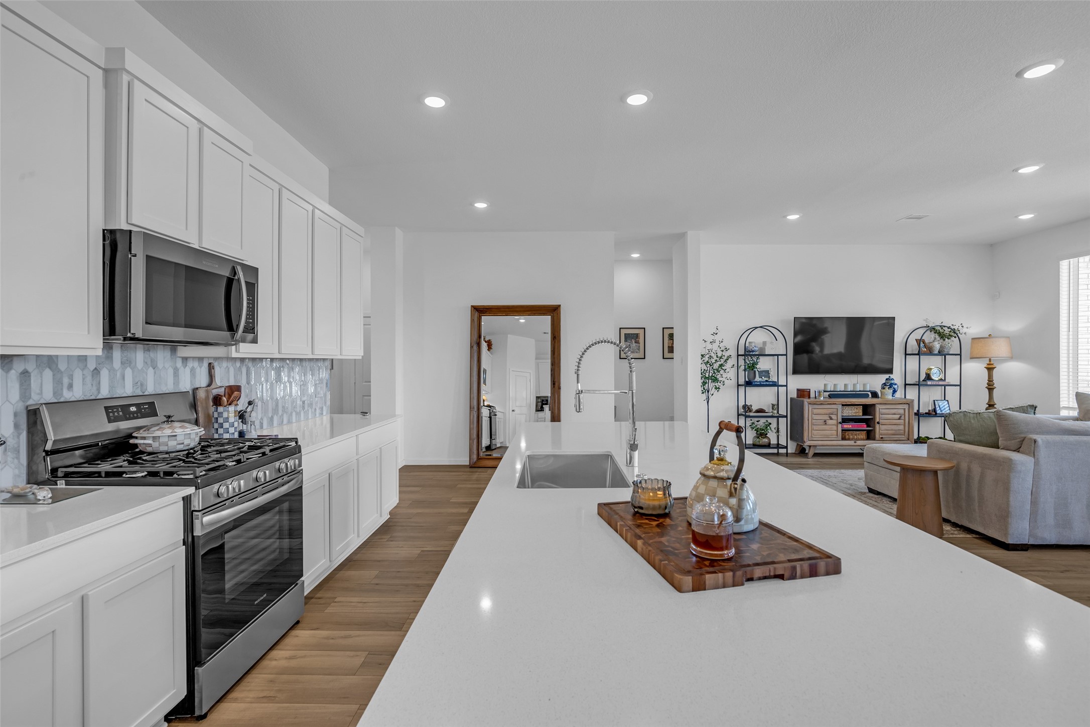 Experience modern living in this open-concept kitchen and living area, featuring sleek stainless steel appliances, ample cabinetry, and a spacious island perfect for entertaining. The adjacent cozy living space offers abundant natural light and a stylish setup for relaxation. Experience modern living in this open-concept kitchen and living area, featuring sleek stainless steel appliances, ample cabinetry, and a spacious island perfect for entertaining. The adjacent cozy living space offers abundant natural light and a stylish setup for relaxation.