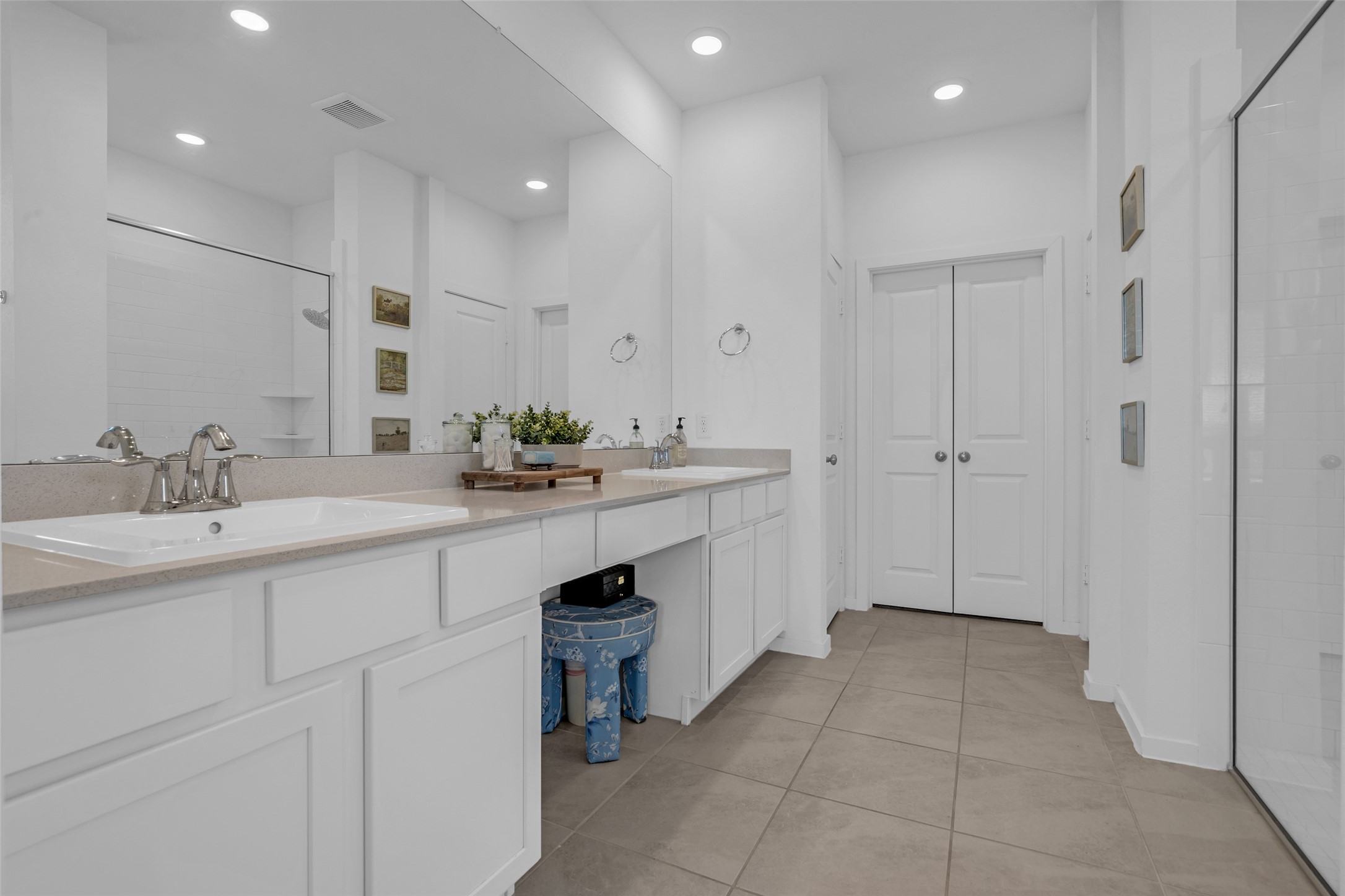 Spacious bathroom featuring dual sinks, modern fixtures, and ample storage with a clean, contemporary design.
