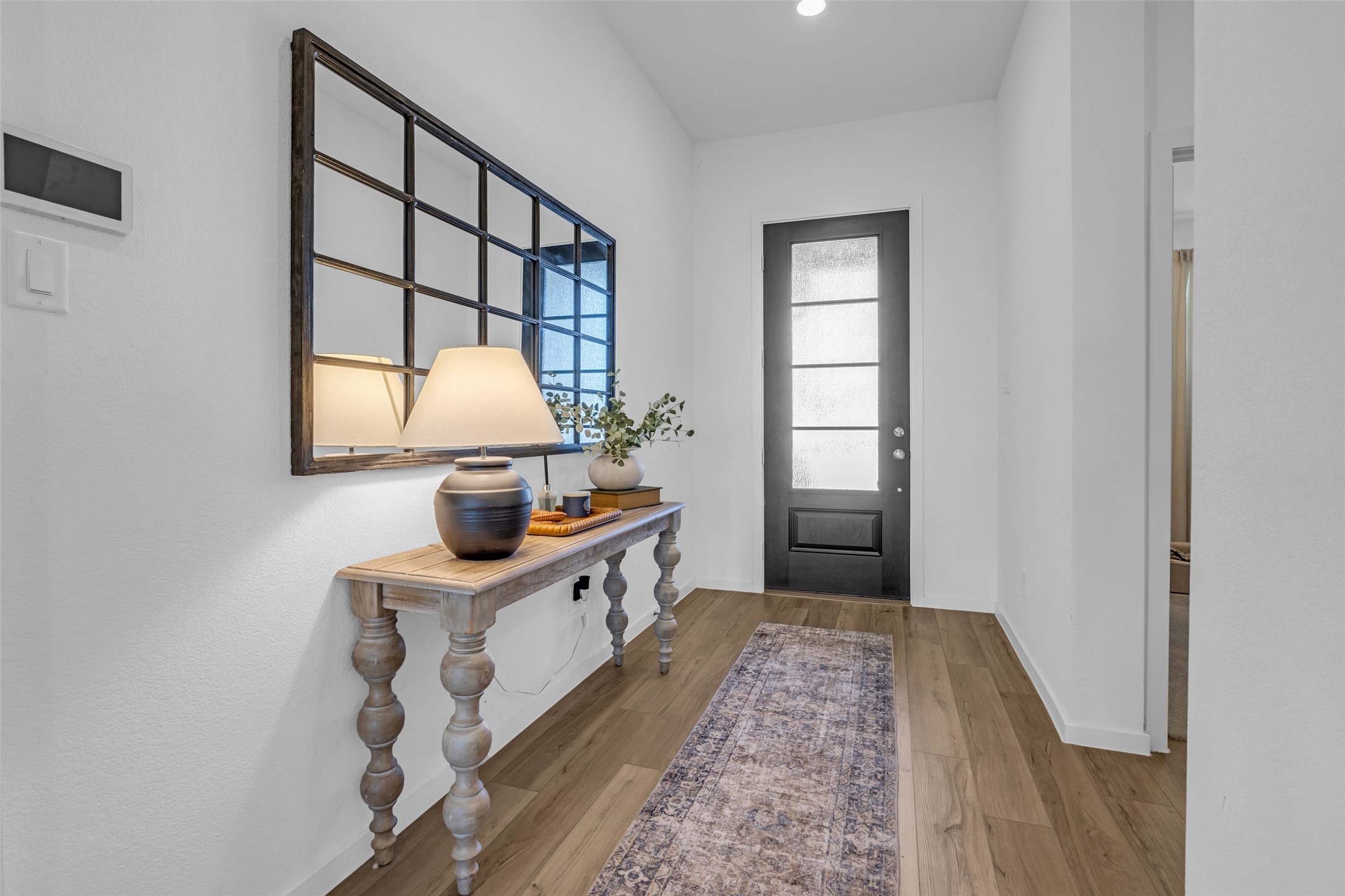 True entryway with elegant wood like flooring, a modern glass-paneled door. True entryway with elegant wood like flooring, a modern glass-paneled door.