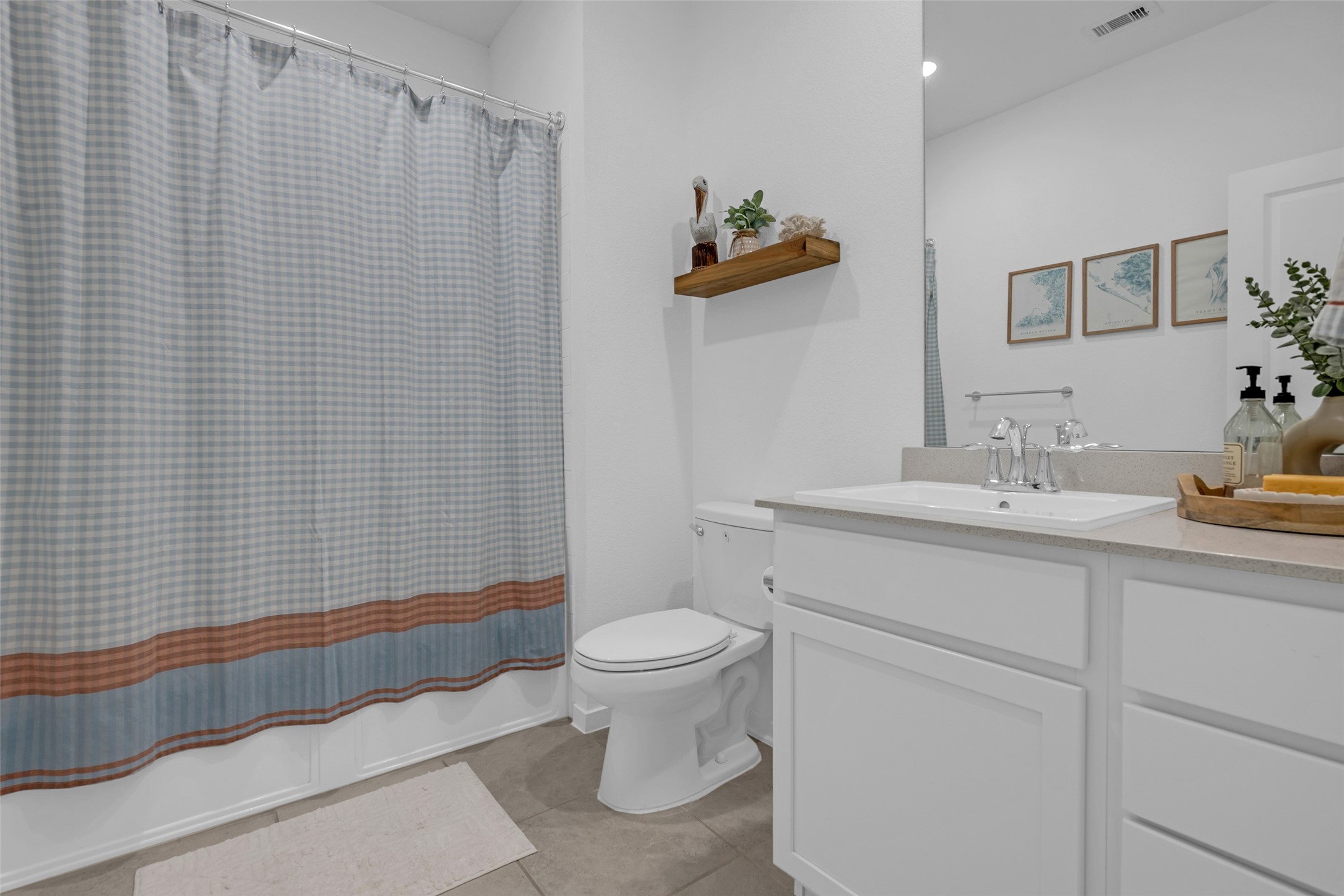 Charming bathroom with a modern sink vanity, stylish shelving, and tasteful decor.