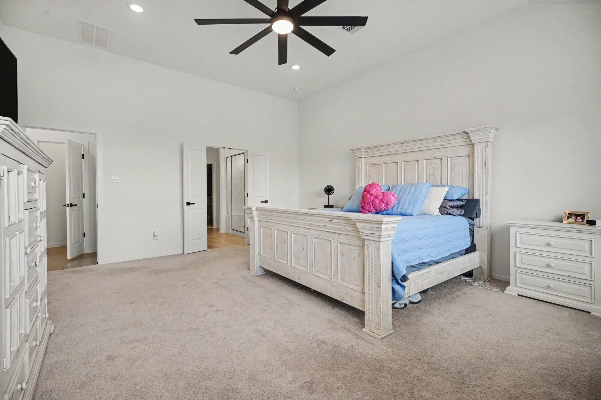 Primary bedroom offers ample space for a variety of furniture arrangements while maintaining a bright and open feel.