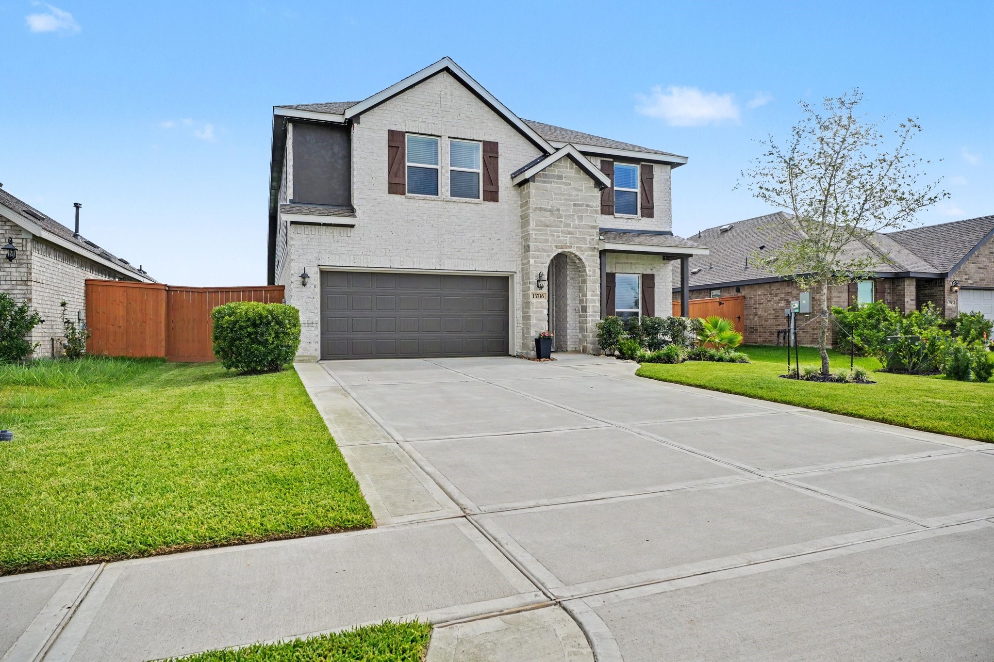 Attractive front exterior showcasing the home's modern design, oversized driveway, and well-maintained lawn. Attractive front exterior showcasing the home's modern design, oversized driveway, and well-maintained lawn.