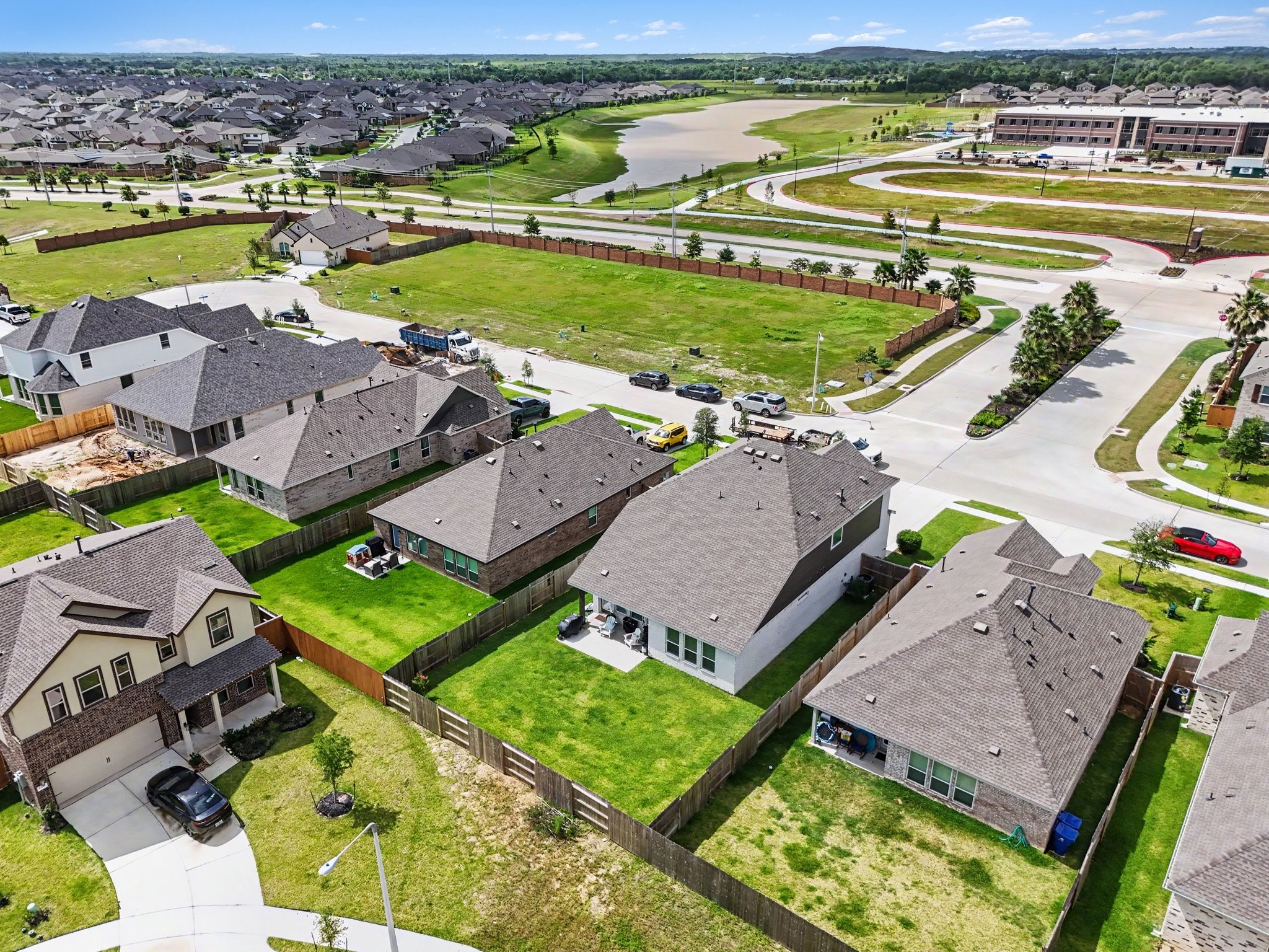 Elevated aerial perspective showcasing the spacious backyard, surrounding homes, and nearby neighborhood amenities.