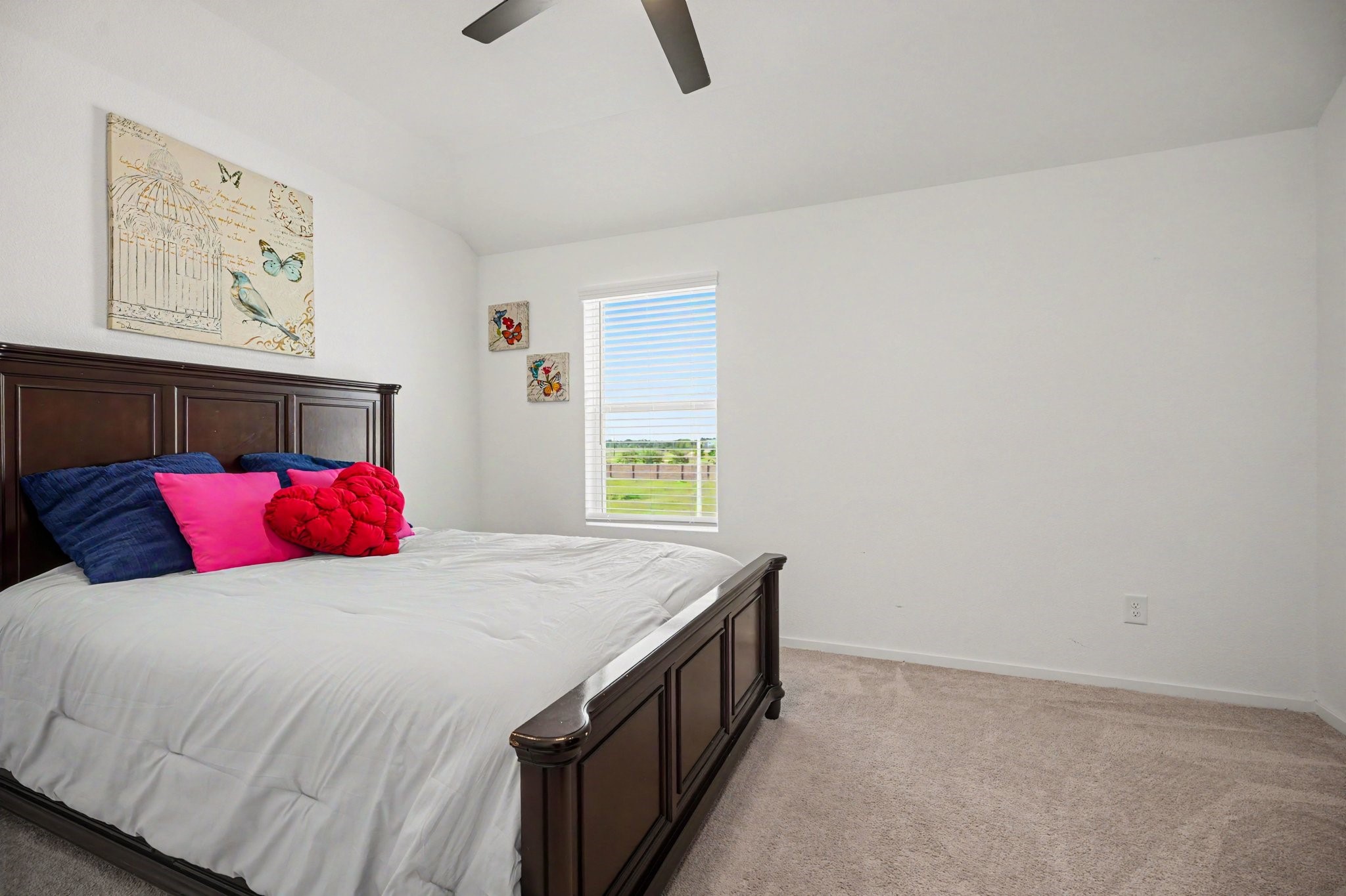 Well-sized secondary bedroom with vaulted ceilings, plush carpeting, and a spacious layout.