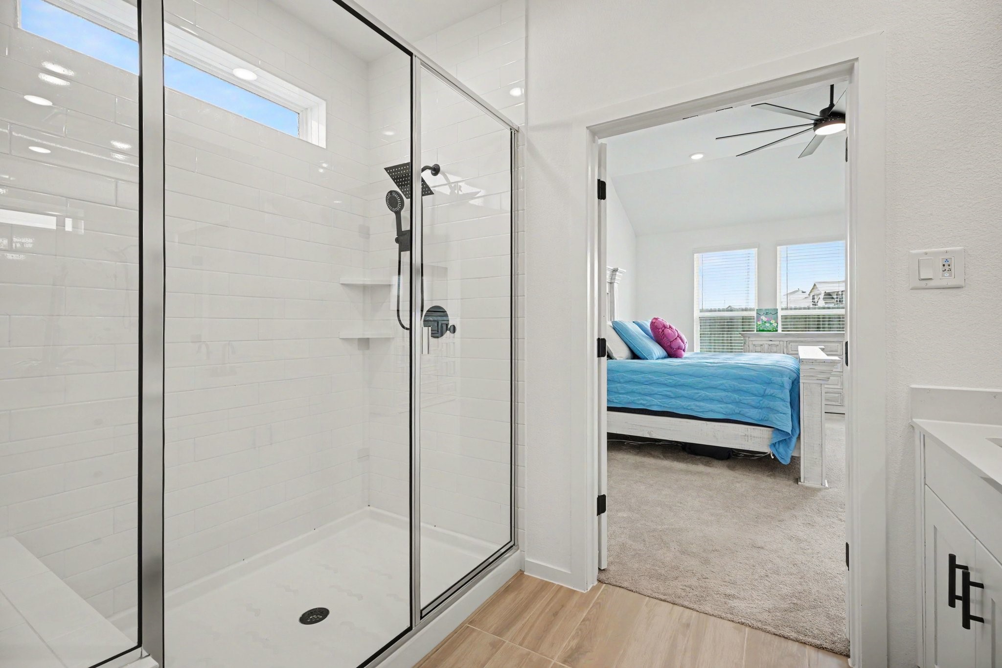 Oversized walk-in shower with frameless glass enclosure, modern fixtures, built-in shelving, and a clean, contemporary design.