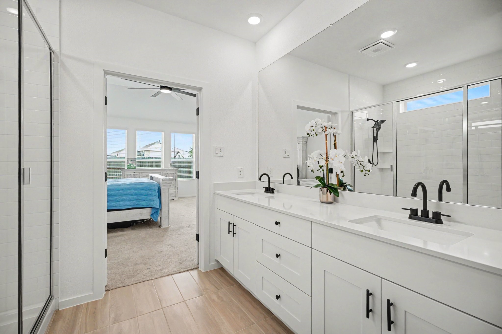 The spacious primary bath offers a functional layout with dual sinks, generous storage, and direct access to the primary suite.