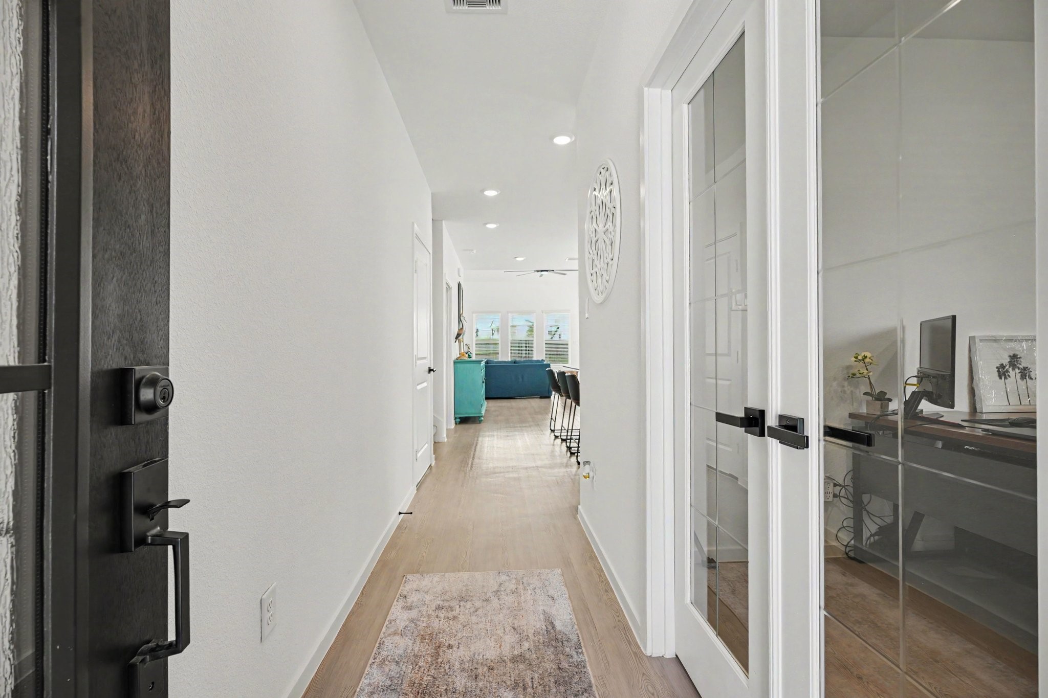 Welcoming entry foyer featuring luxury vinyl plank flooring, modern finishes, and a private study with glass French doors. Welcoming entry foyer featuring luxury vinyl plank flooring, modern finishes, and a private study with glass French doors.