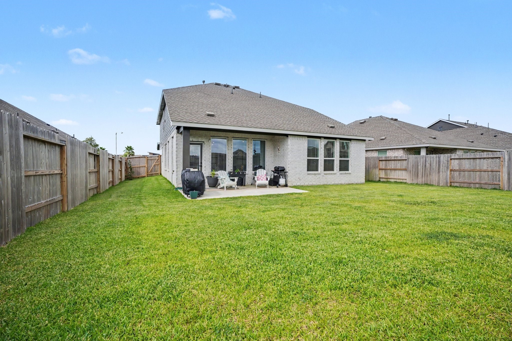 Fully fenced backyard offering plenty of green space for outdoor activities, gardening, or pets.