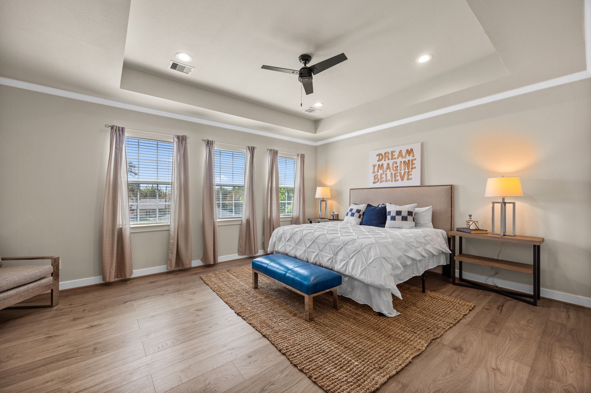 Welcome to the primary bedroom suite! Notice NO CARPET throughout the entire home. This large 15x19 FT room offers plenty of natural light, tray ceilings as well as crown molding.