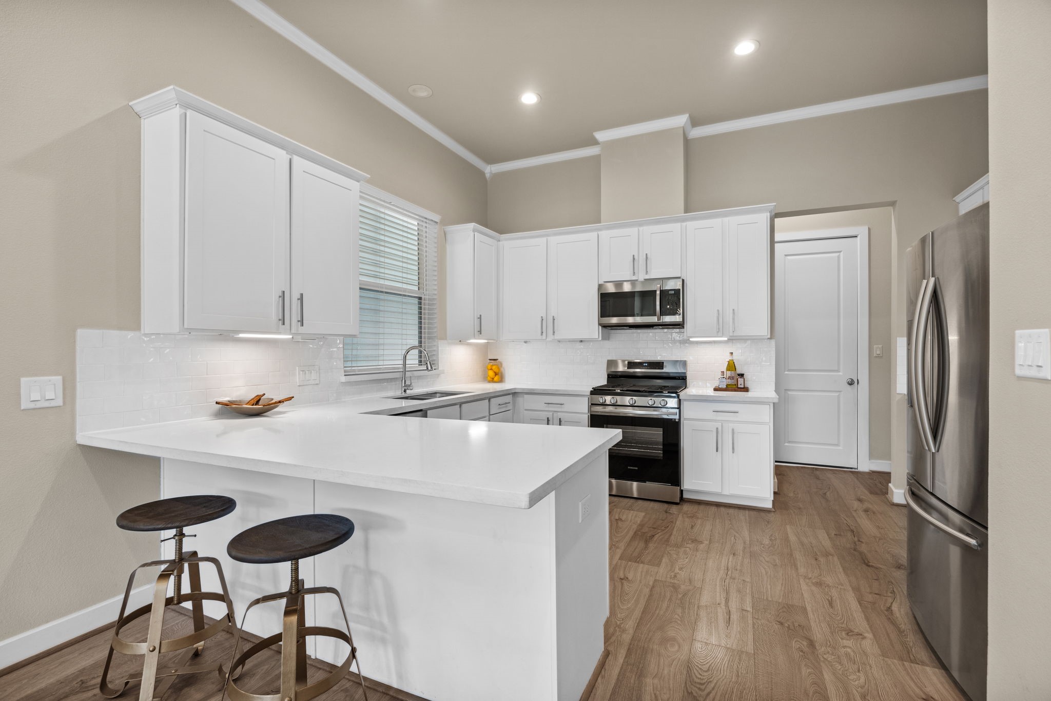 Light and airy is the name of the game! The kitchen features Quartz Countertops, subway tile backsplash, shaker style cabinetry and stainless steel appliances.
