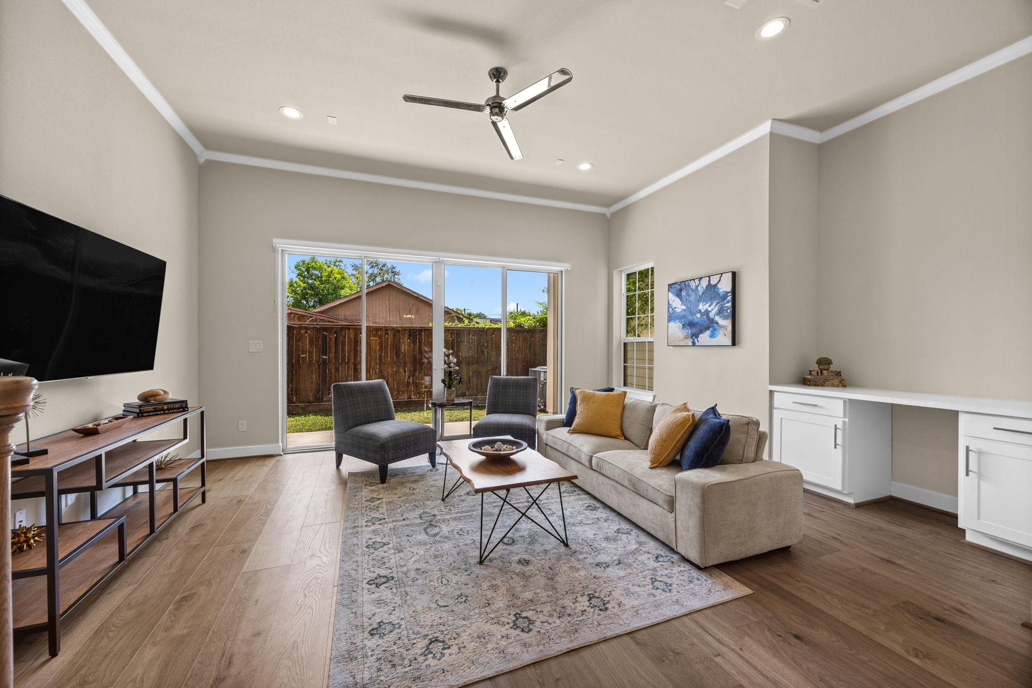 Notice how light and bright the living area is. Large furniture welcome! Crown molding was added as an upgrade. The built-ins in the back of the room work great as an office nook, or even a built-in bar area with space for a beverage fridge.