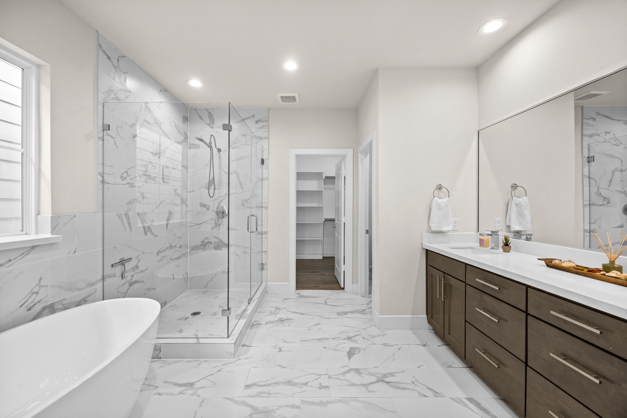 Peaceful mornings begin in your spa-like primary bathroom. Free-standing soaking tub, oversized shower with frameless glass surround and dual sink vanity.