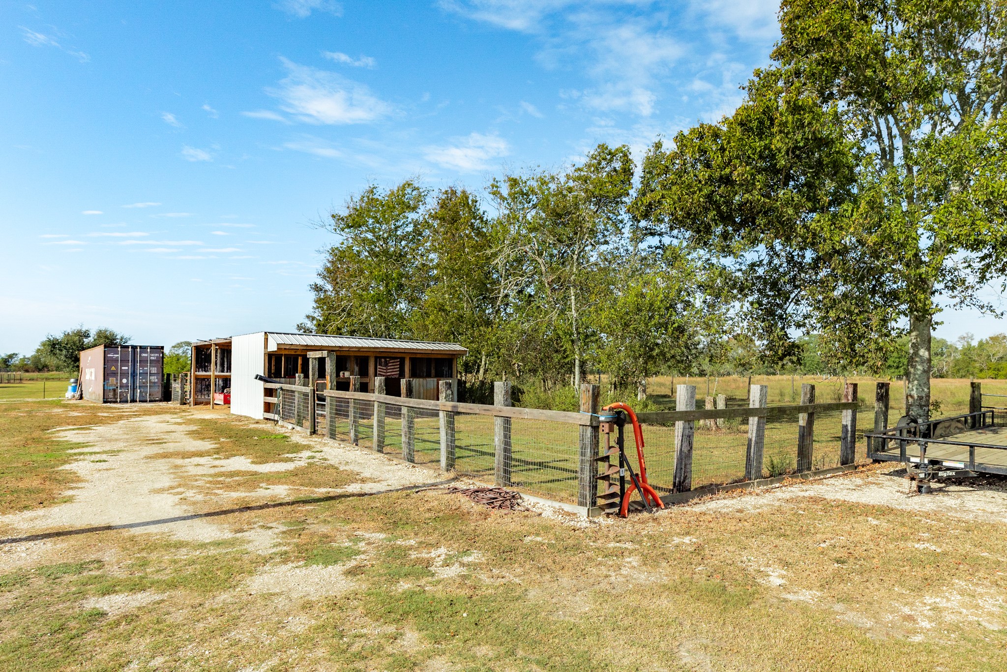 Barn with covered storage and fenced areas.