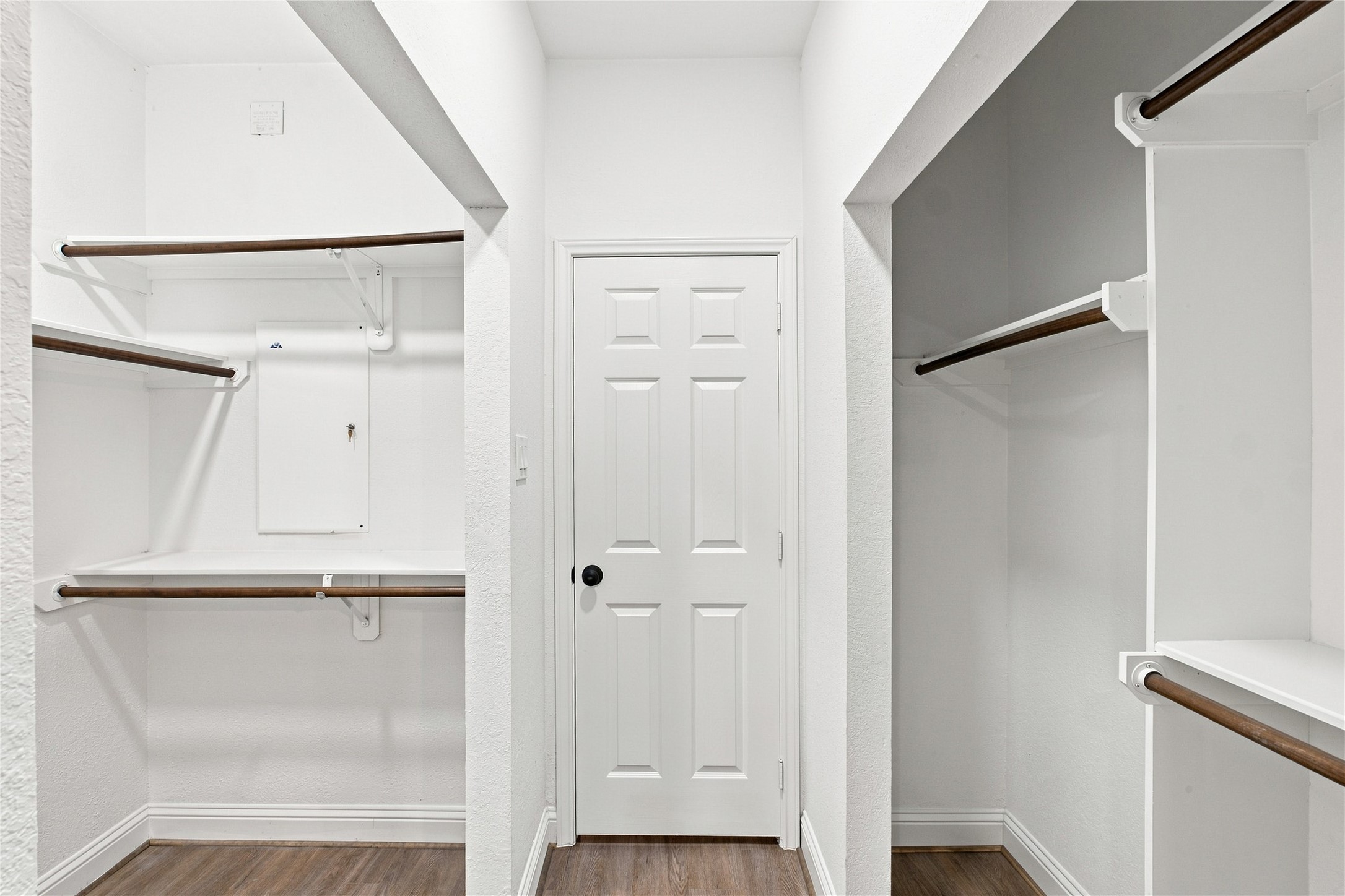 The primary walk-in closet offers multiple hanging areas and built-in shelving for organized storage.