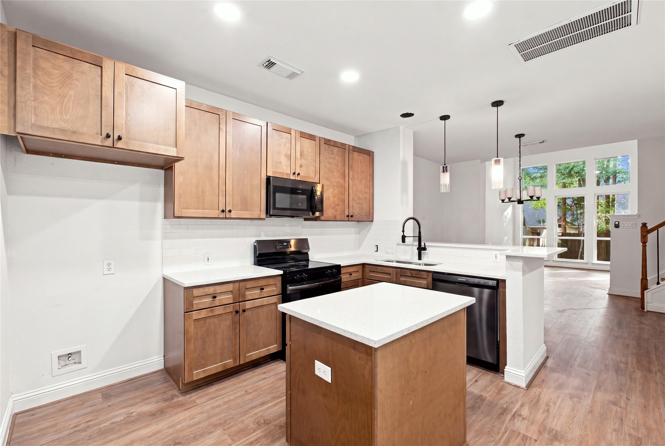 The center island adds prep space, with a clear view into the living room and out through the wall of windows.