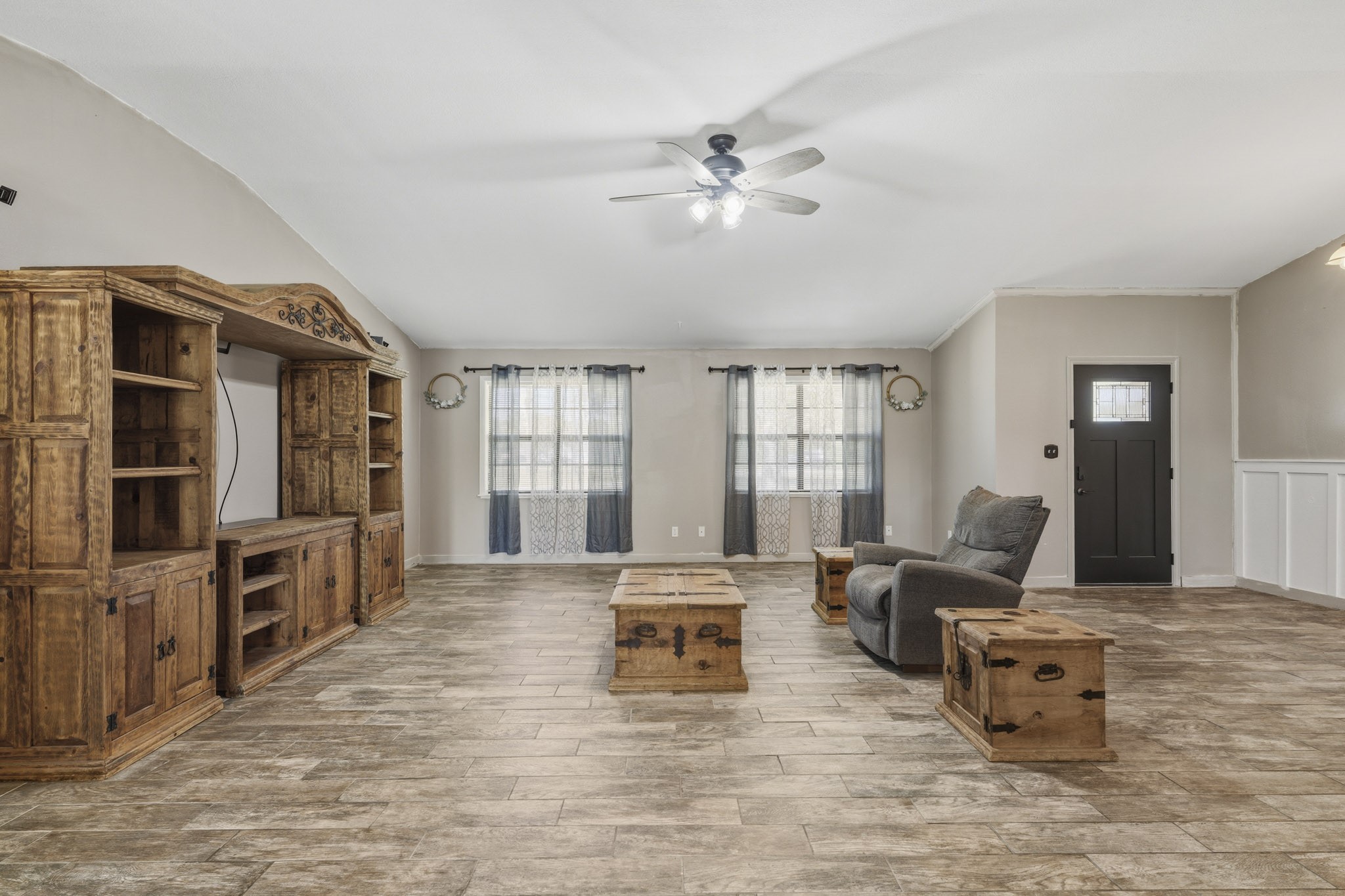 Spacious living room featuring elegant tile flooring, and abundant natural light from large windows, creating a warm and inviting atmosphere. Spacious living room featuring elegant tile flooring, and abundant natural light from large windows, creating a warm and inviting atmosphere.