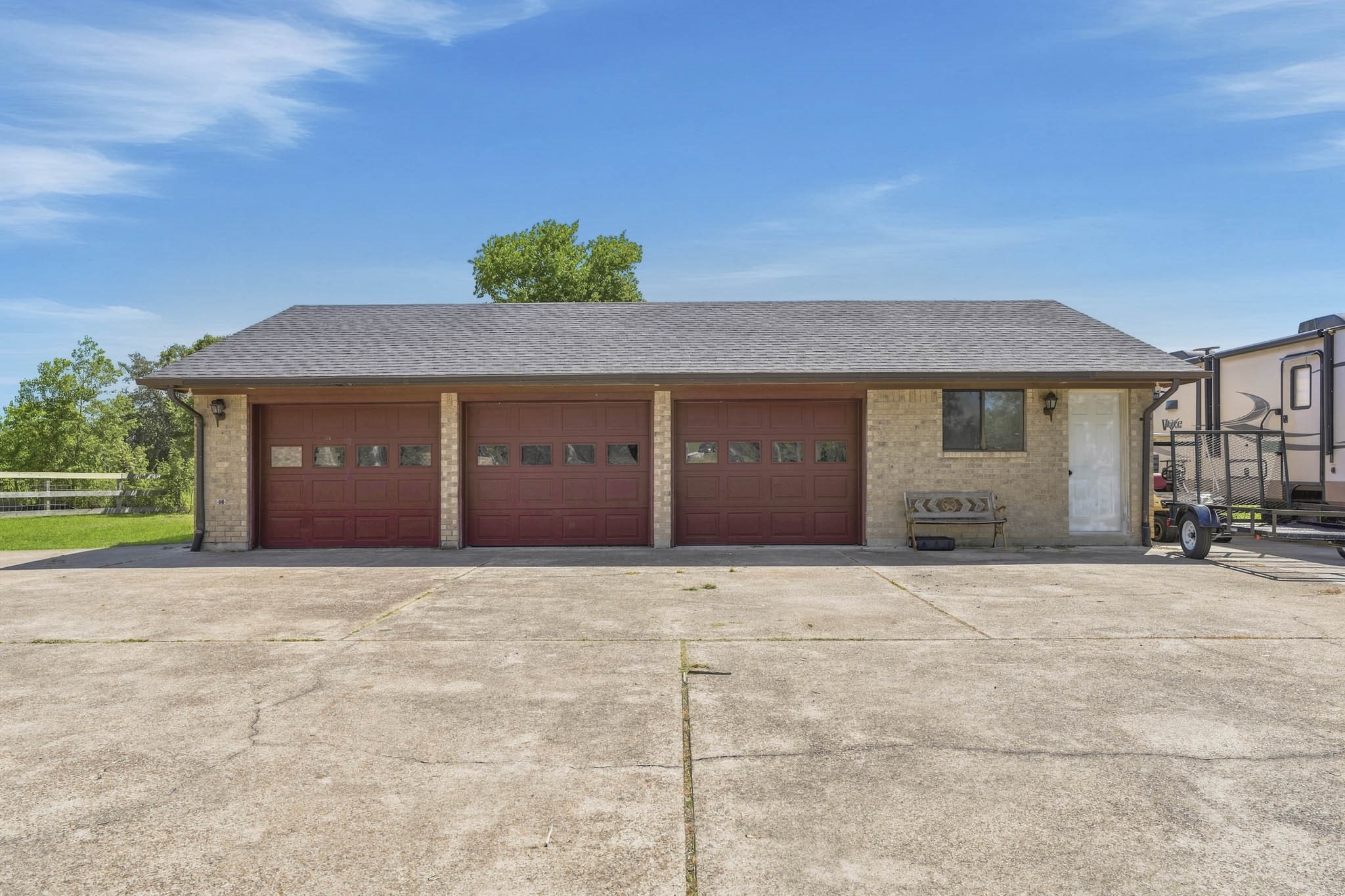 Spacious three-car oversized garage with classic brick exterior, complemented by a wide driveway for ample parking.
