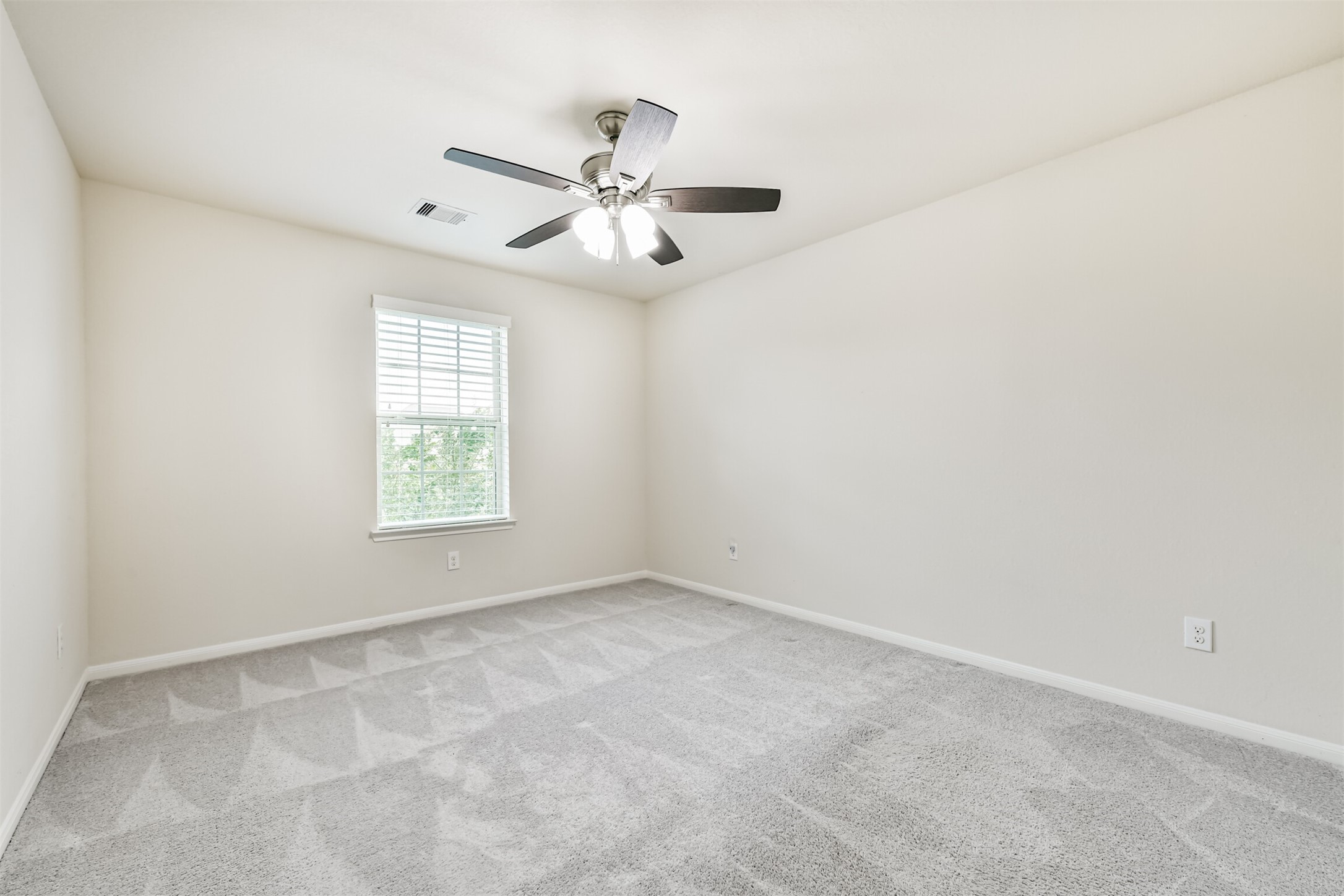 Bedroom 4 - Spacious upstairs bedroom with abundant natural light and modern ceiling fan.