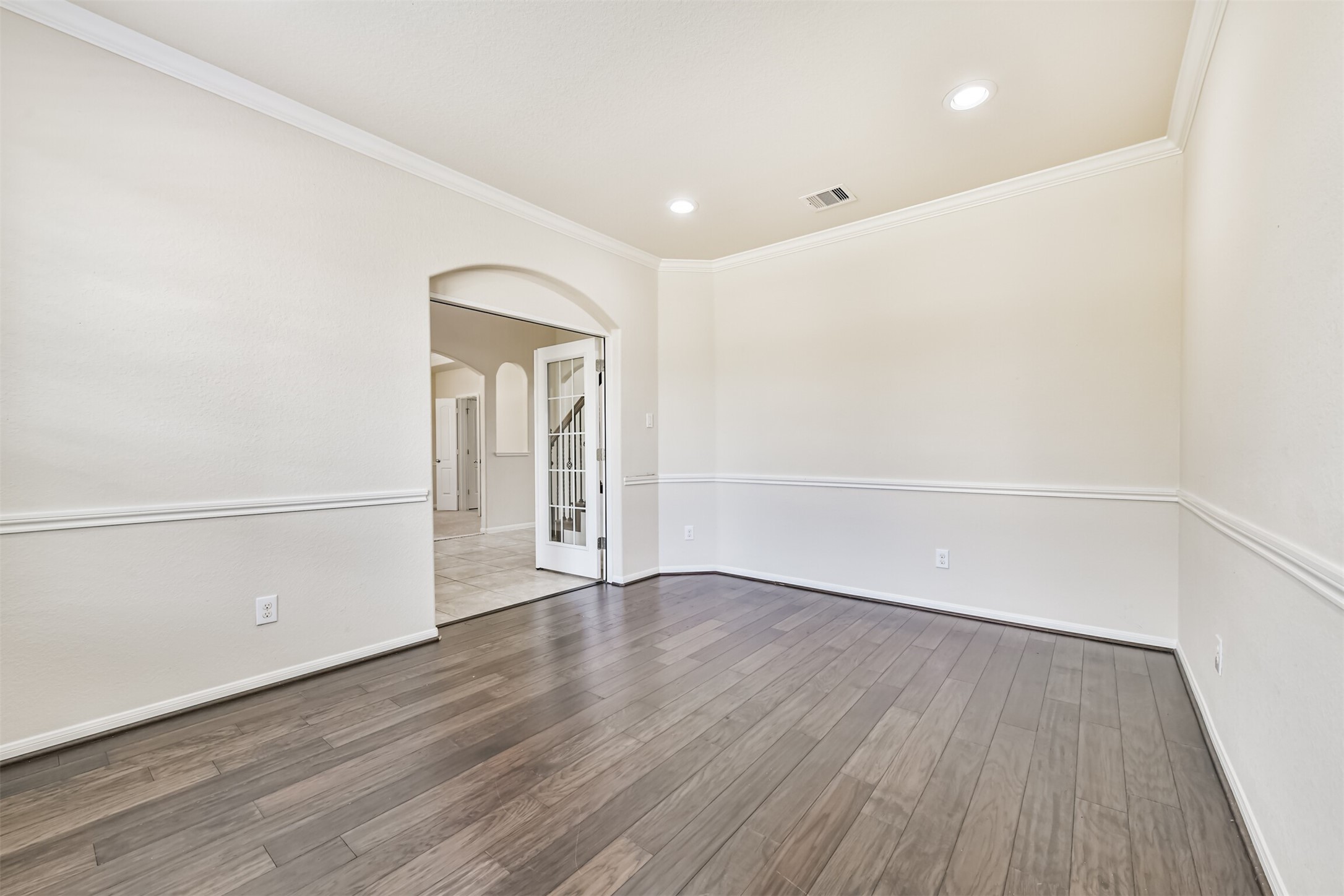 Elegant living space featuring rich floors, crown molding, and recessed lighting, perfect for stylish entertaining and relaxation.