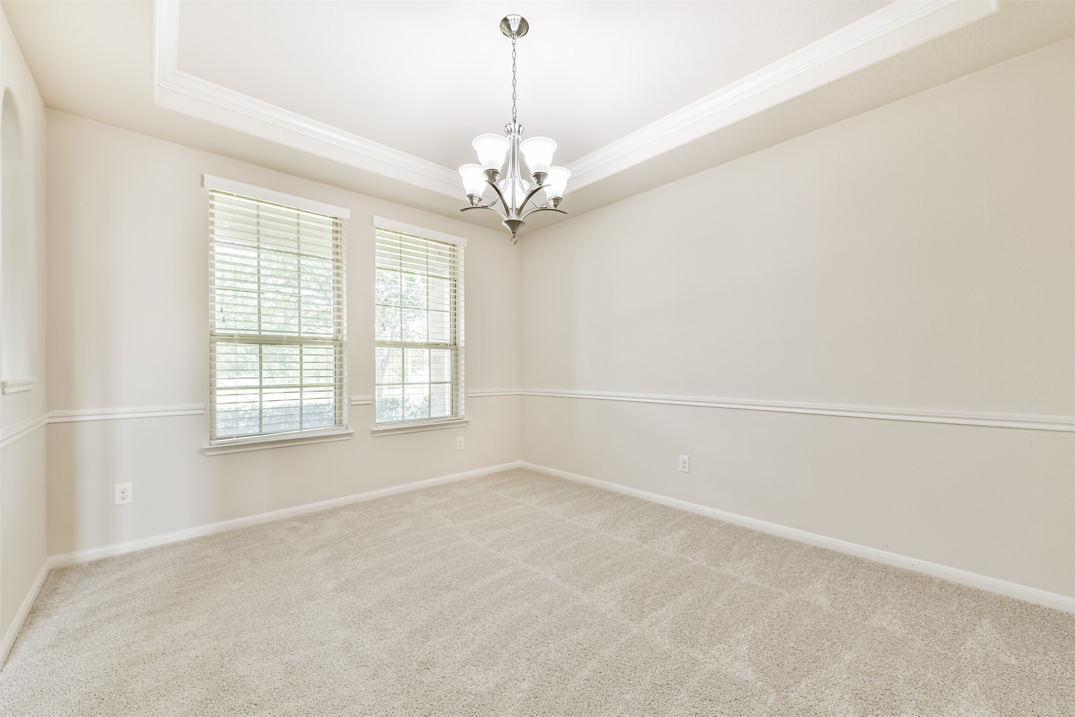 Elegant formal dining room featuring abundant natural light and sophisticated crown molding, perfect for hosting memorable gatherings.