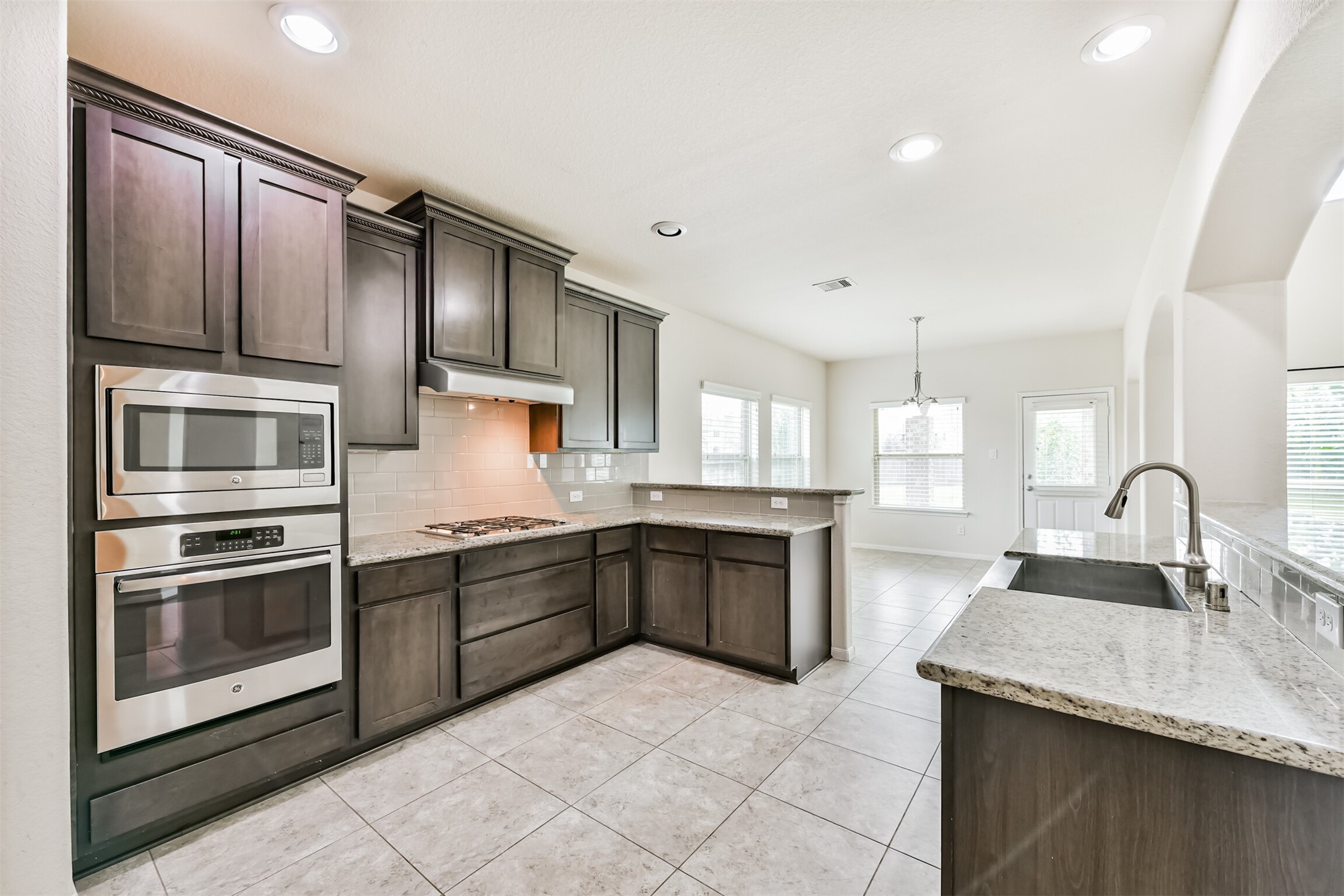 This modern kitchen features sleek granite countertops, stainless steel appliances, and elegant cabinetry. With its open layout and abundant natural light, it's perfect for cooking and entertaining.
