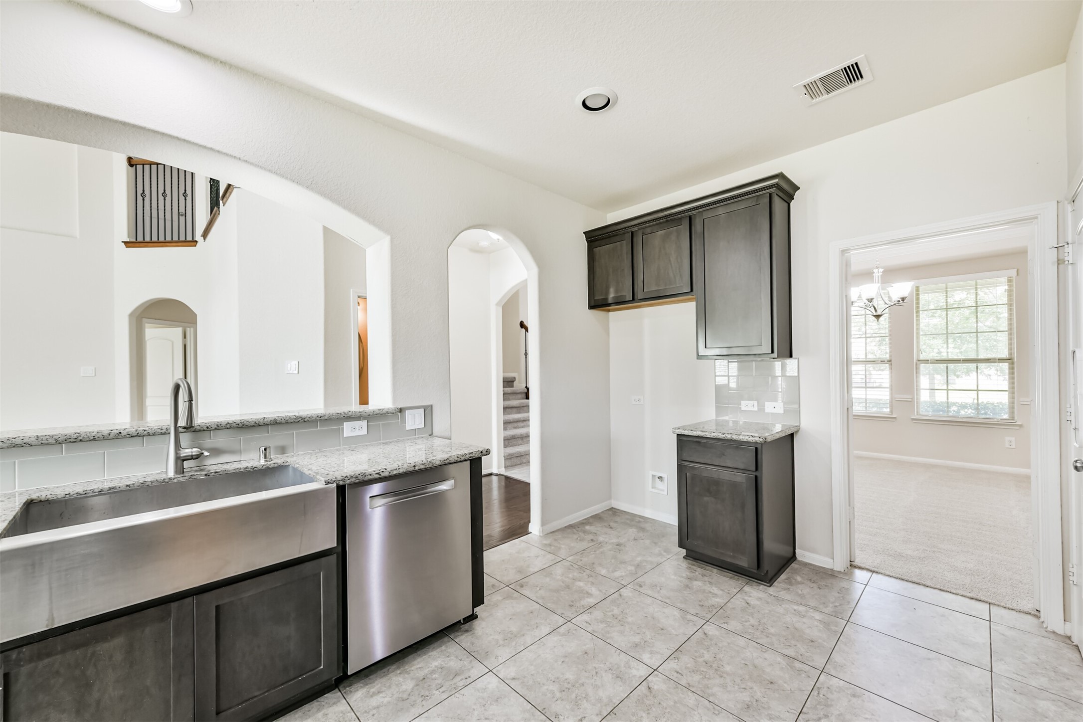 Modern kitchen with sleek granite countertops, stainless steel appliances, and ample cabinet space, perfect for culinary enthusiasts.