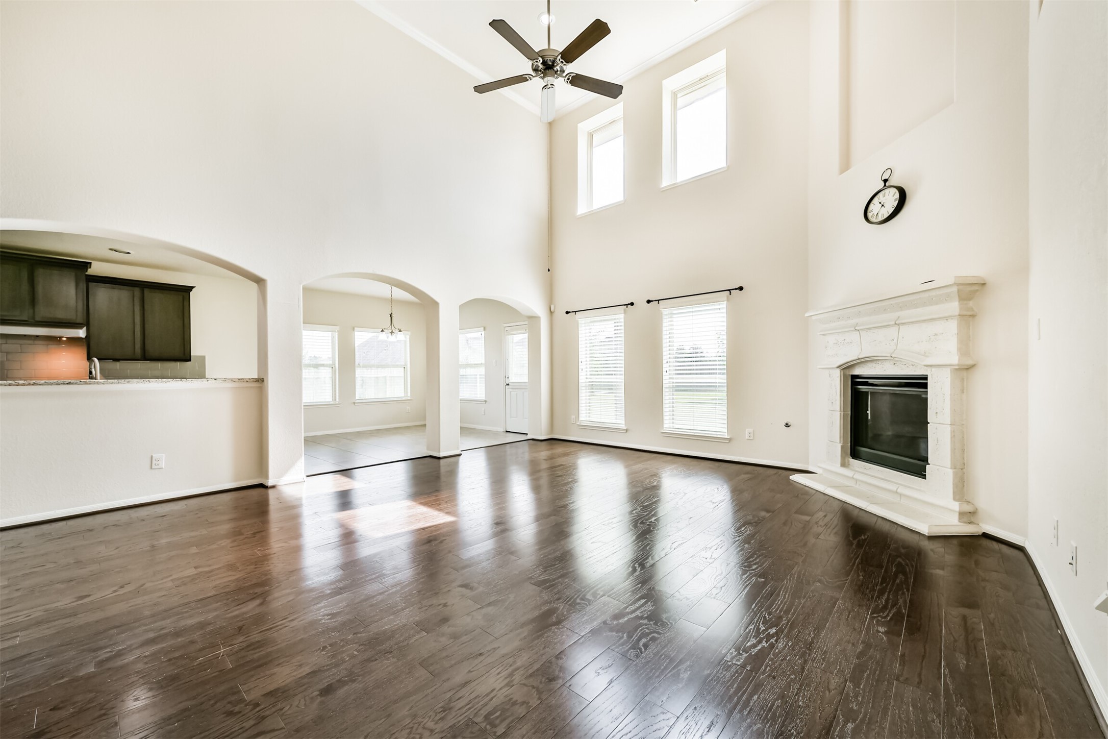 Bright and spacious living area with soaring ceilings, elegant floors, and a cozy fireplace. Perfect for entertaining and relaxing.