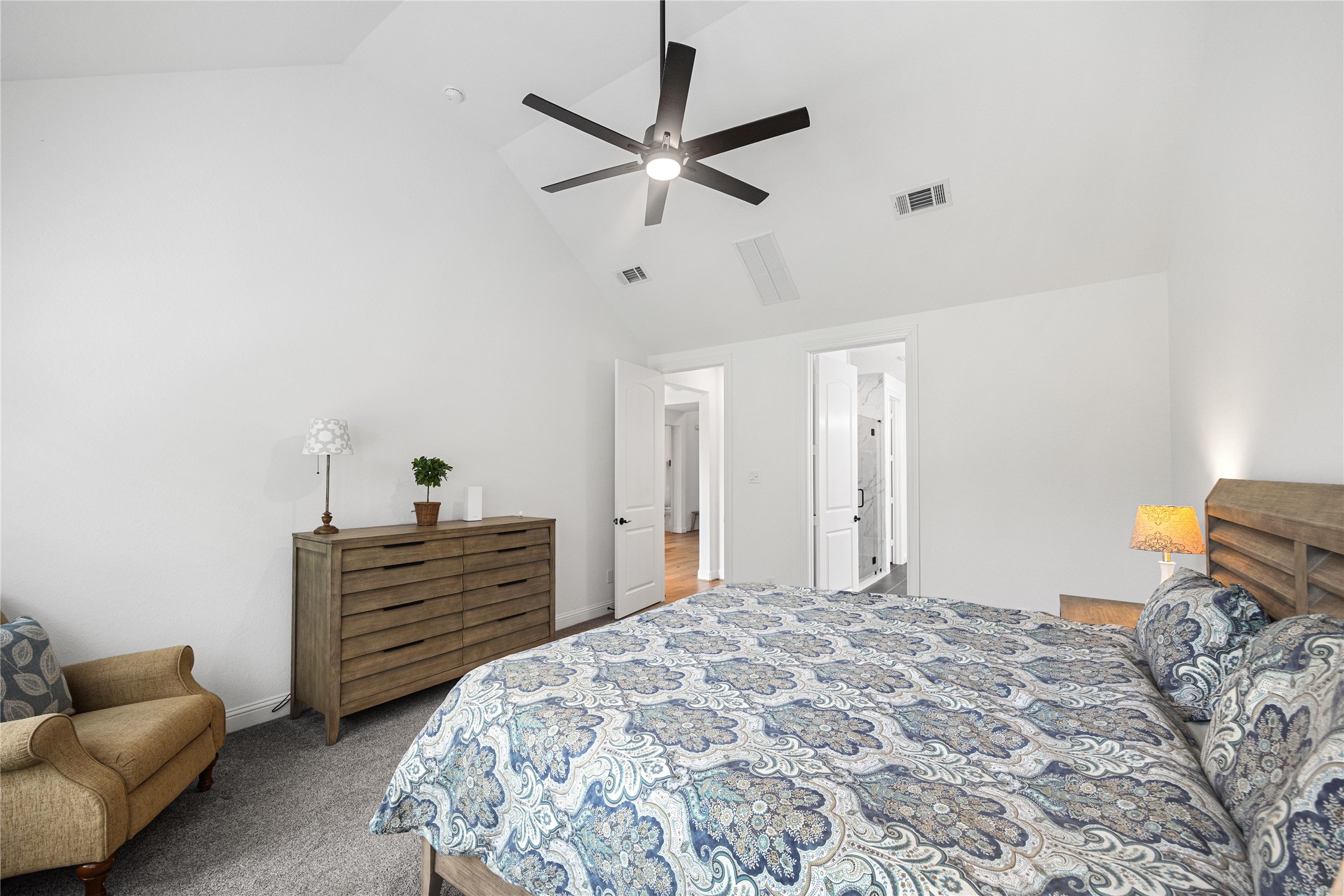 Primary bedroom with high ceilings and ensuite bathroom.