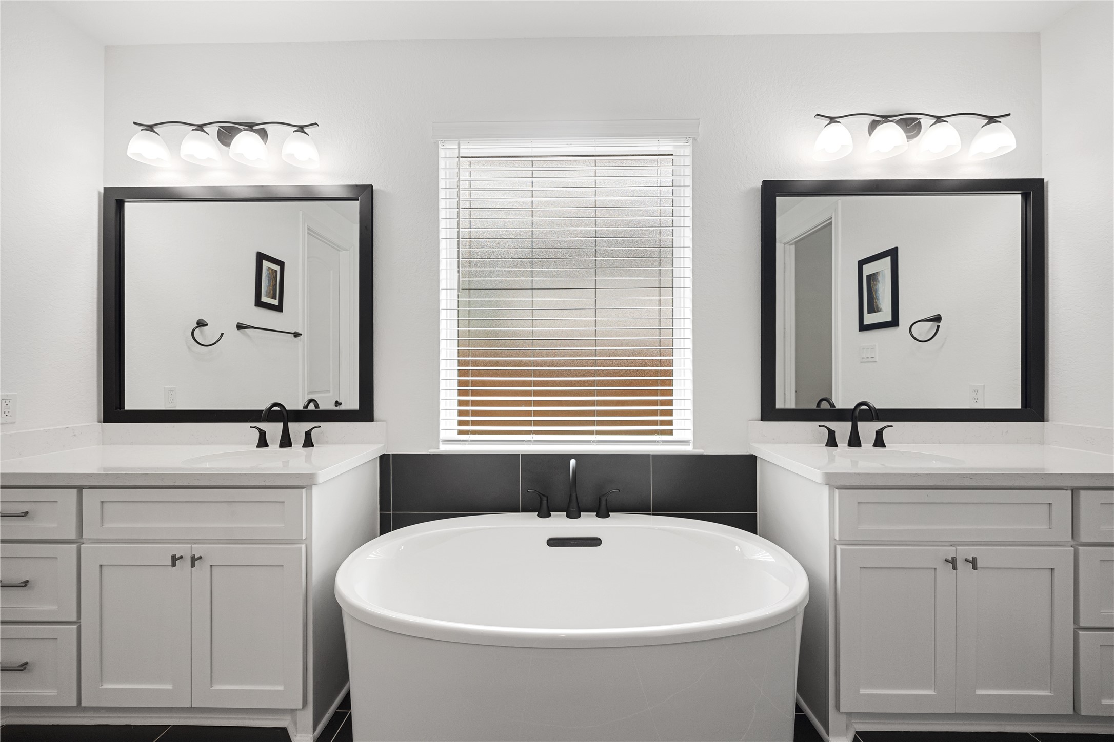 Dual sinks and large soaking tub with elevated finishes.