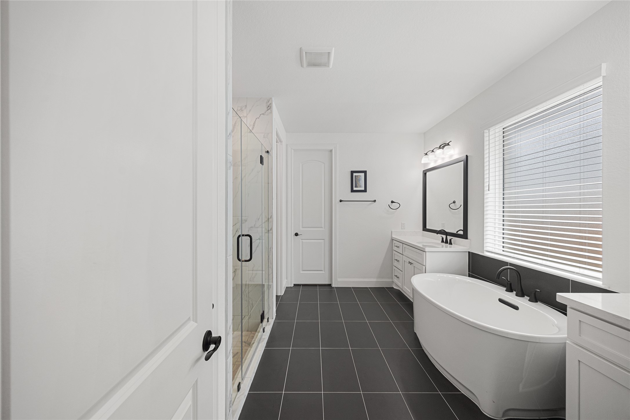 Dual sinks and large soaking tub with elevated finishes.