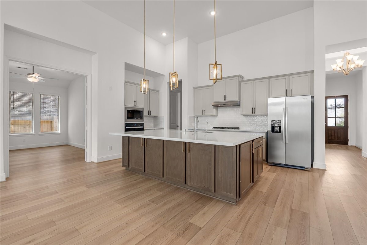 The beautifully appointed kitchen opens seamlessly to the living room and features an oversized island, stainless steel appliances, and 42-inch cabinetry with crown molding.
