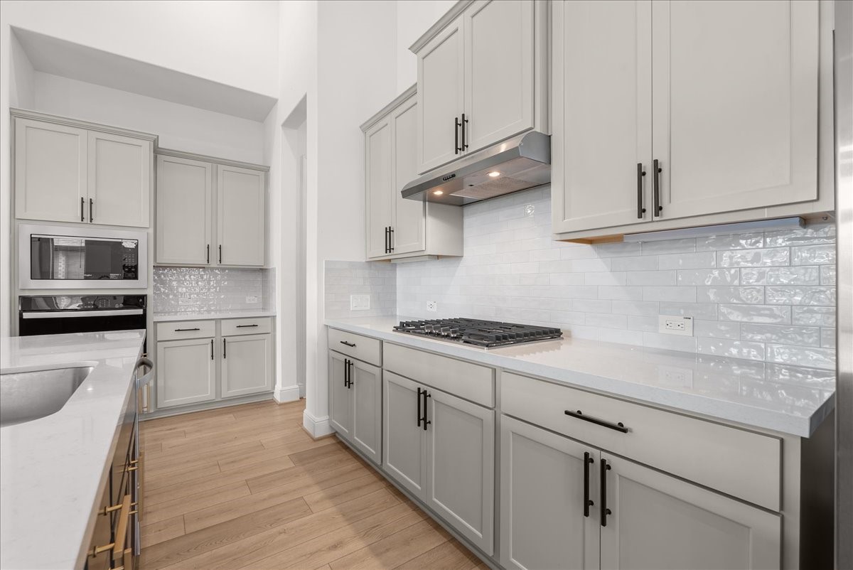 The beautifully appointed kitchen opens seamlessly to the living room and features an oversized island, stainless steel appliances, and 42-inch cabinetry with crown molding.